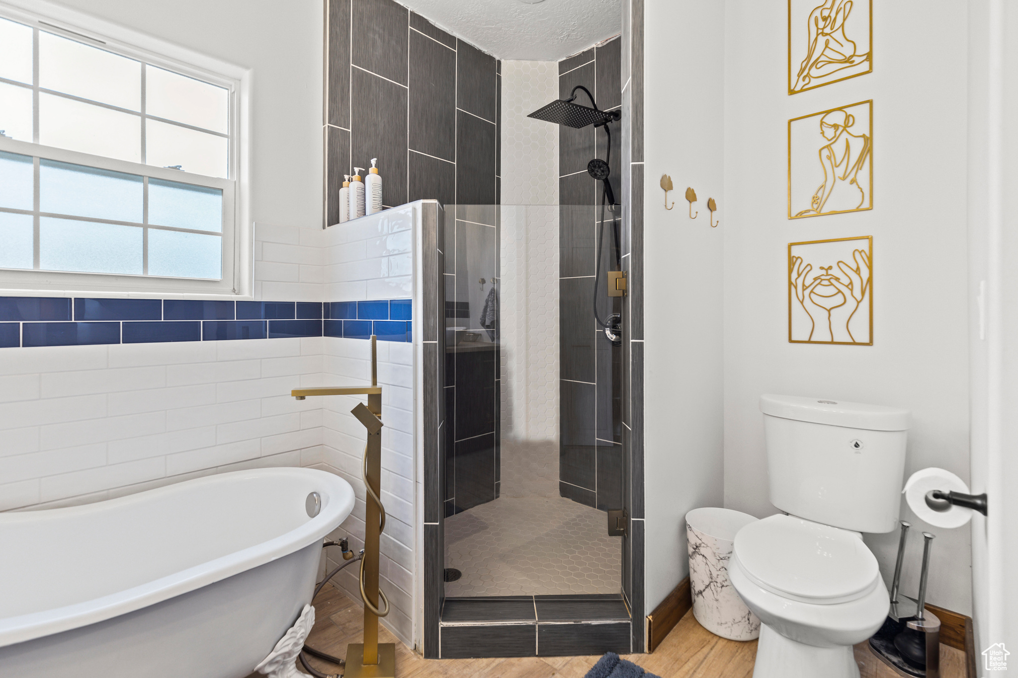 Bathroom featuring toilet, wood-type flooring, and shower with separate bathtub