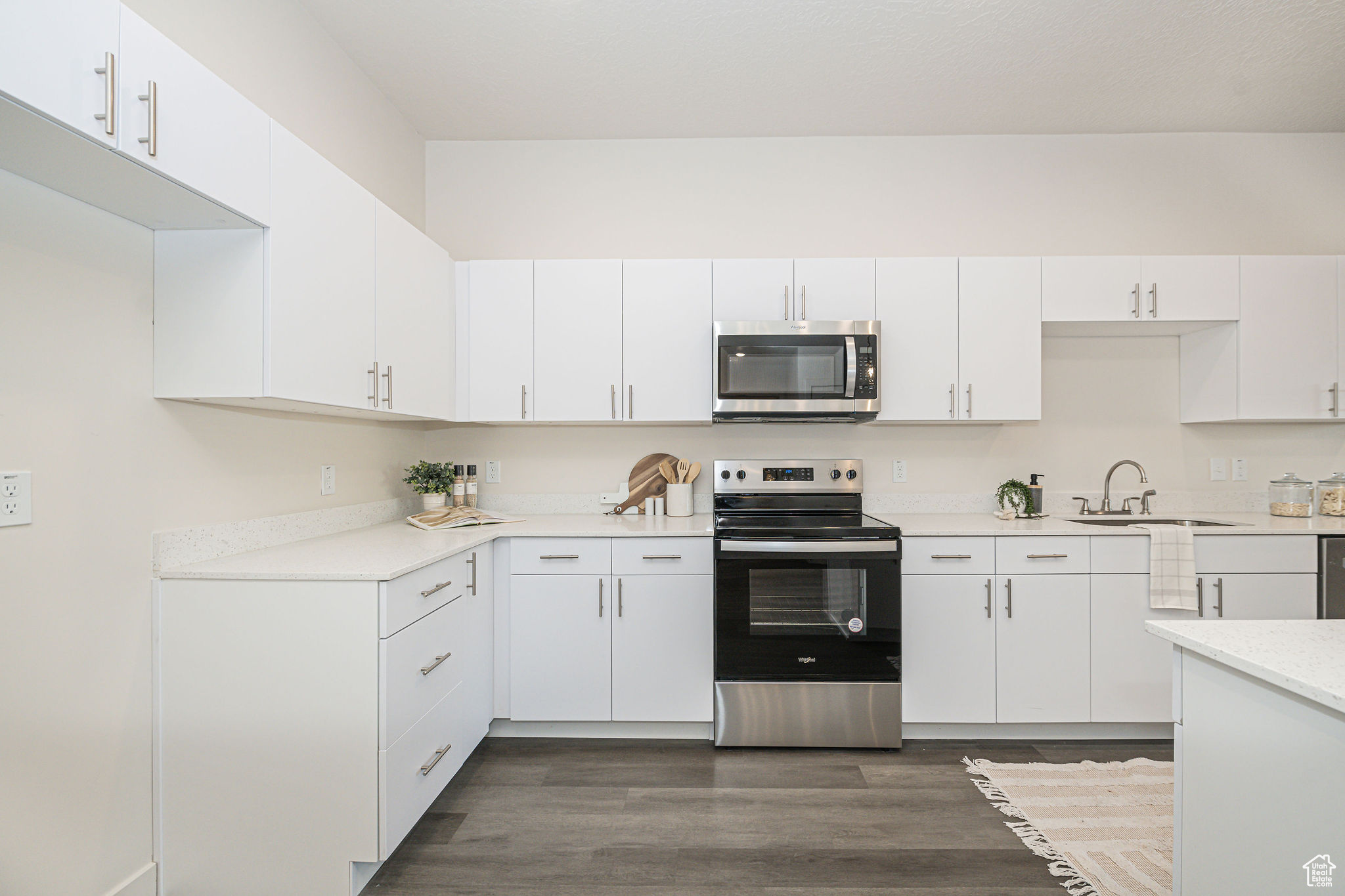 Kitchen featuring appliances with stainless steel finishes, white cabinets, and sink