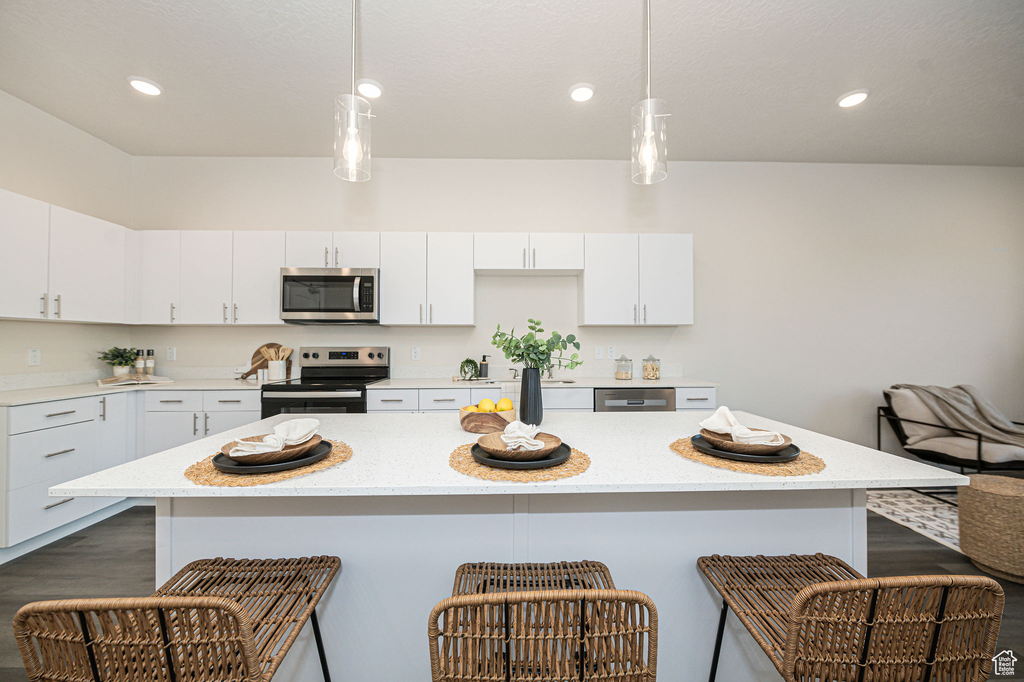 Kitchen featuring white cabinets, a kitchen bar, appliances with stainless steel finishes, and a kitchen island