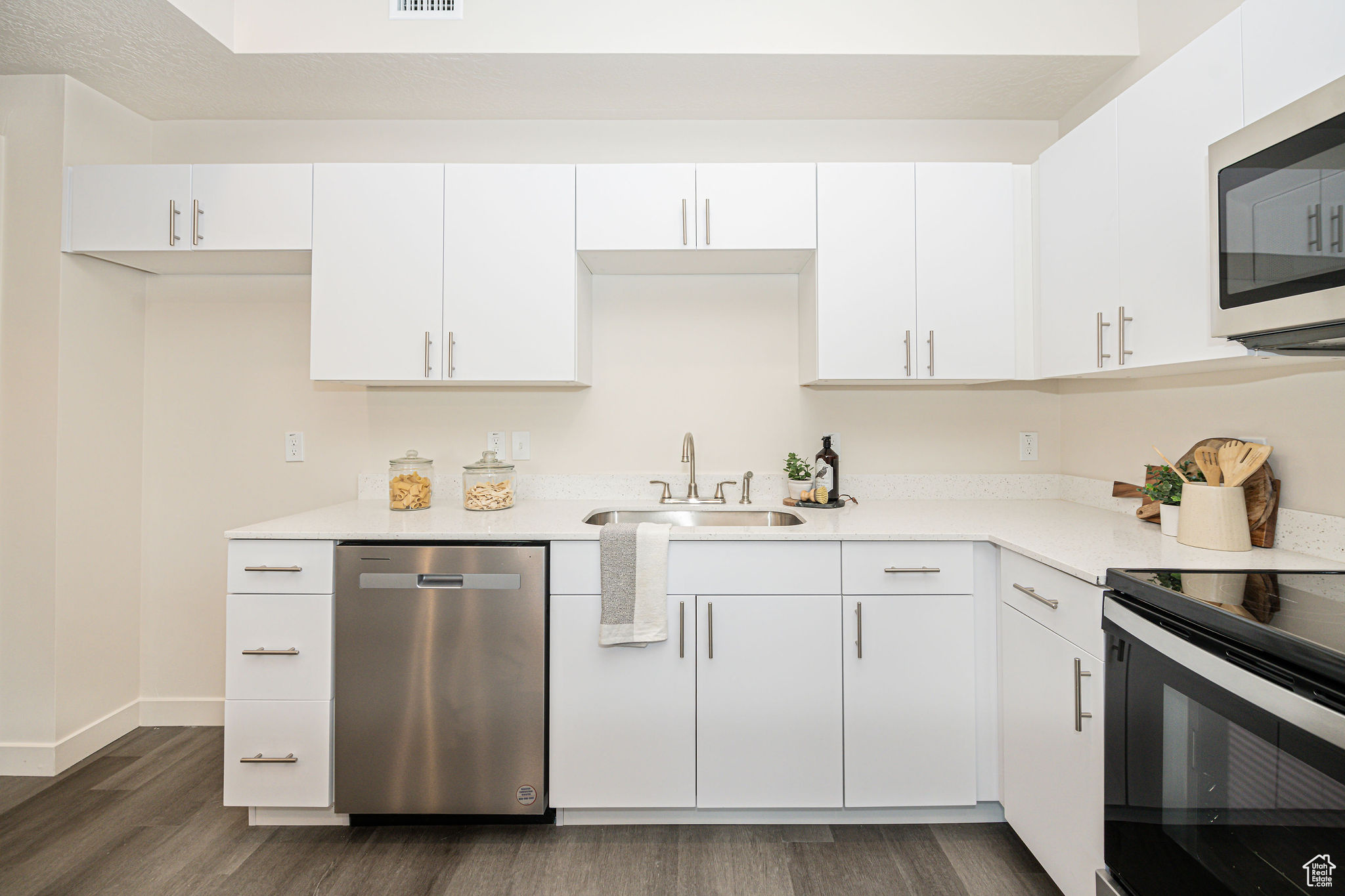 Kitchen featuring sink, white cabinetry, and appliances with stainless steel finishes