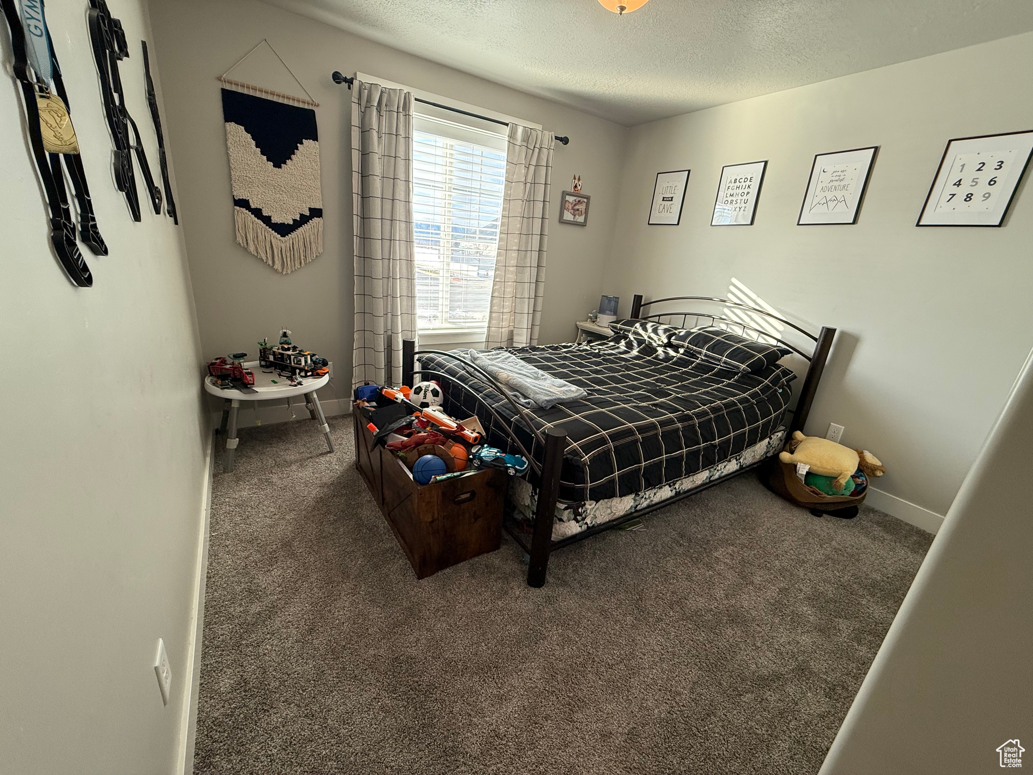 Bedroom with a textured ceiling and carpet floors