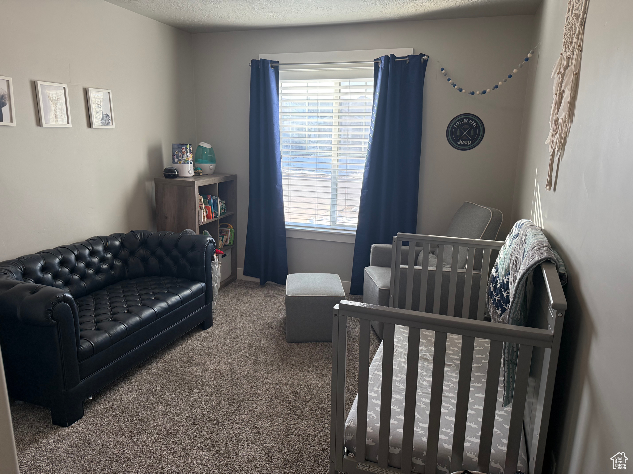 Bedroom featuring a nursery area and carpet flooring