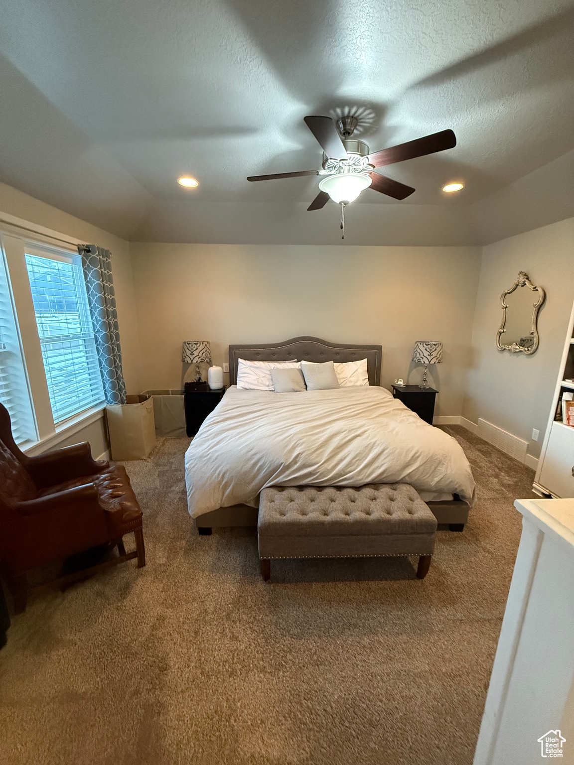 Carpeted bedroom with a textured ceiling and ceiling fan