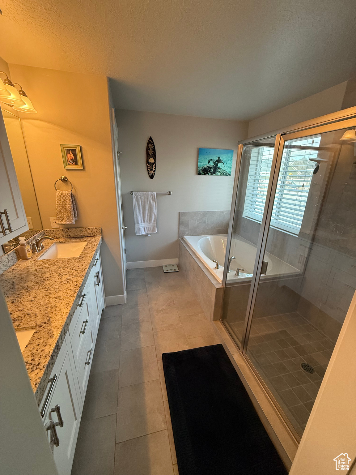 Bathroom featuring a textured ceiling, tile patterned floors, vanity, and shower with separate bathtub