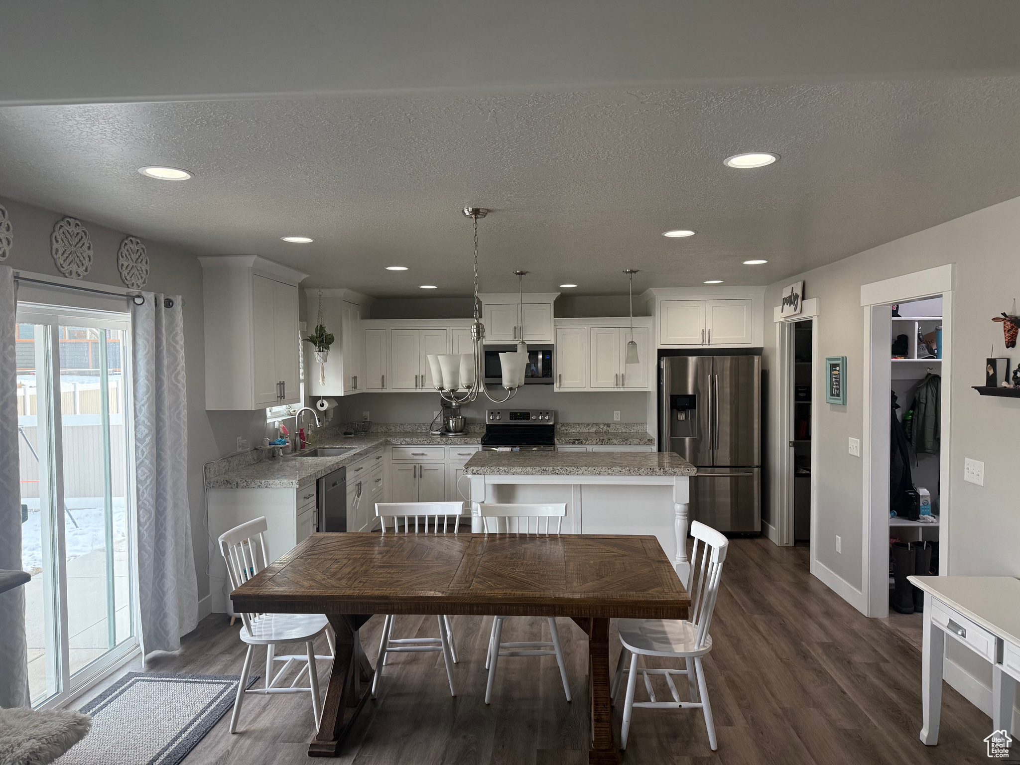 Dining area with a textured ceiling, dark wood-type flooring, and sink