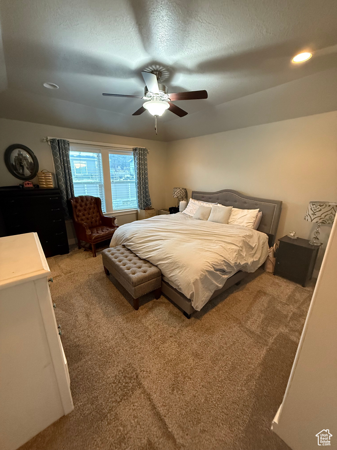 Bedroom featuring ceiling fan, a textured ceiling, and carpet flooring