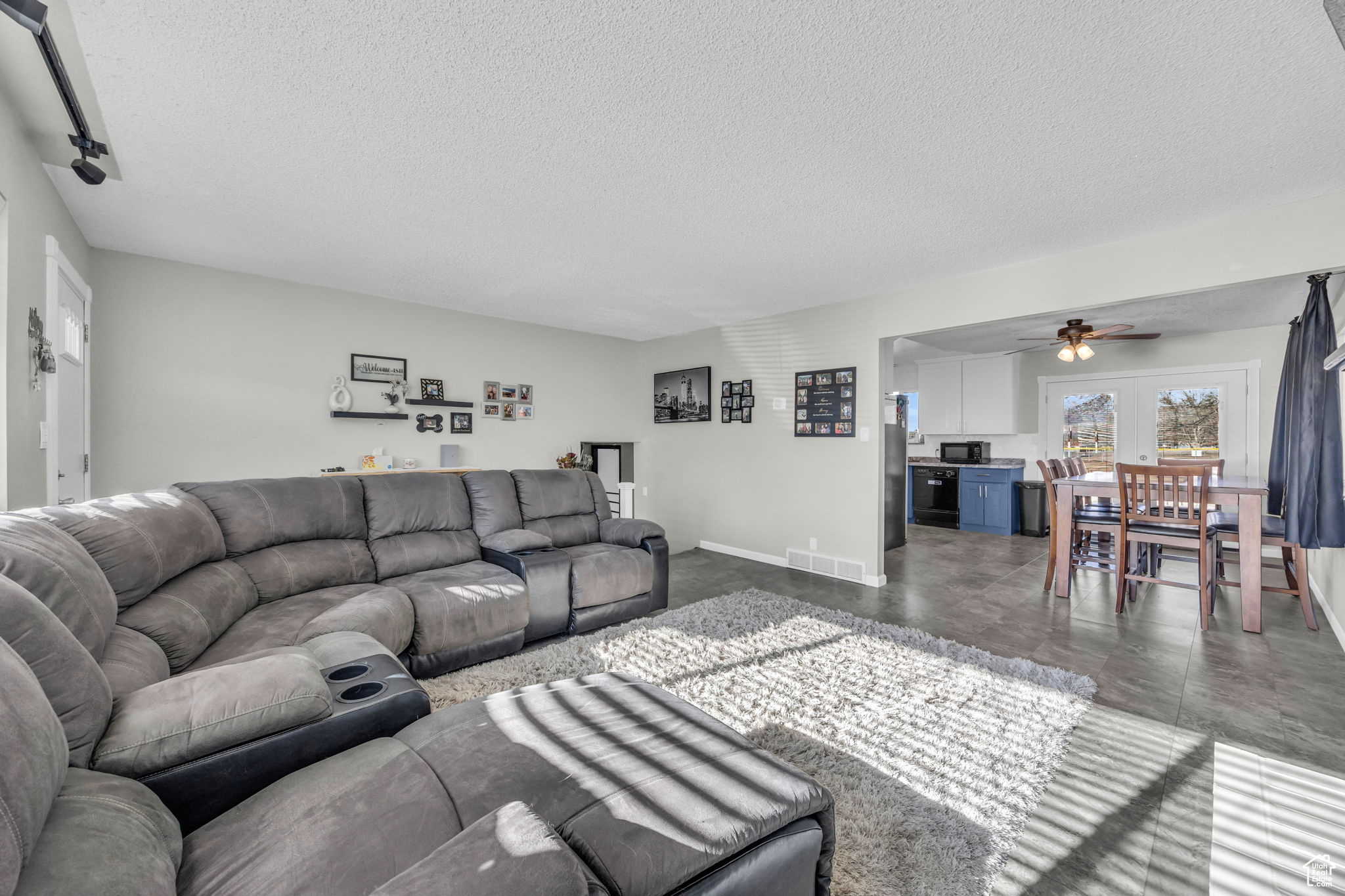 Living room featuring a textured ceiling and ceiling fan