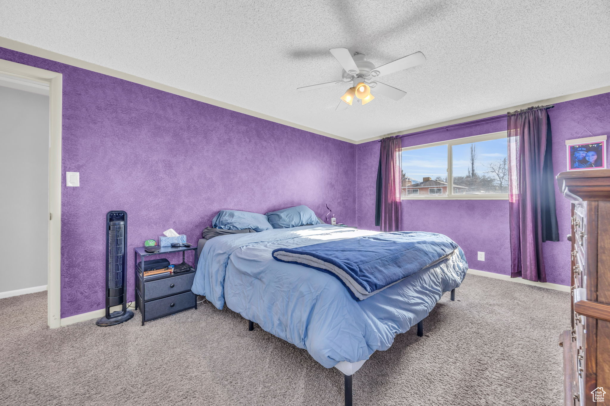 Bedroom with a textured ceiling, ceiling fan, and light colored carpet