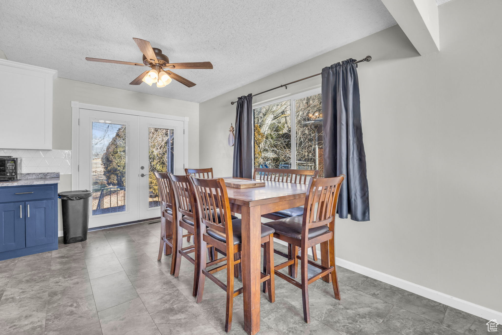 Dining room featuring a textured ceiling, a wealth of natural light, and french doors