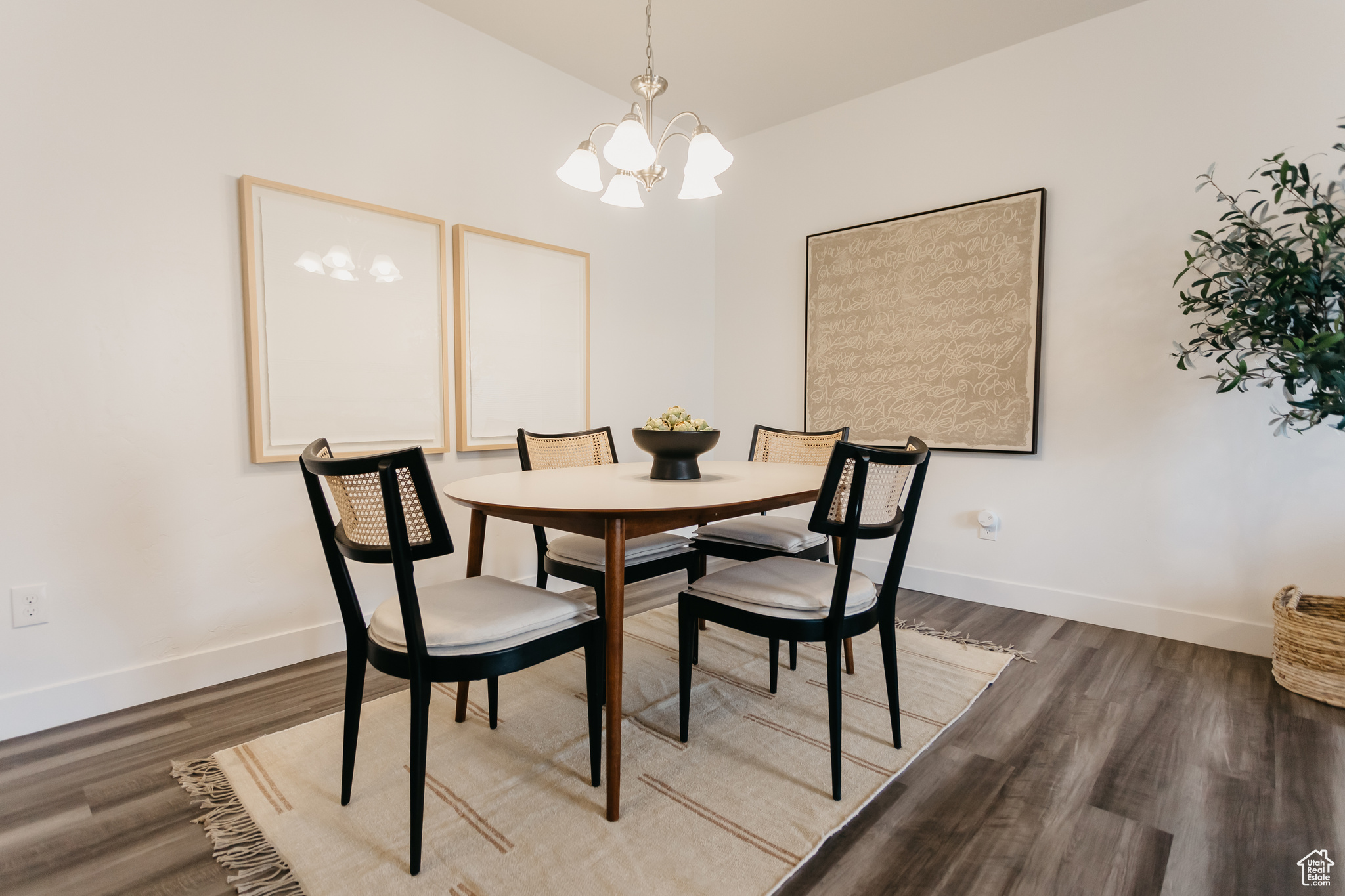 Dining room with wood-type flooring and an inviting chandelier