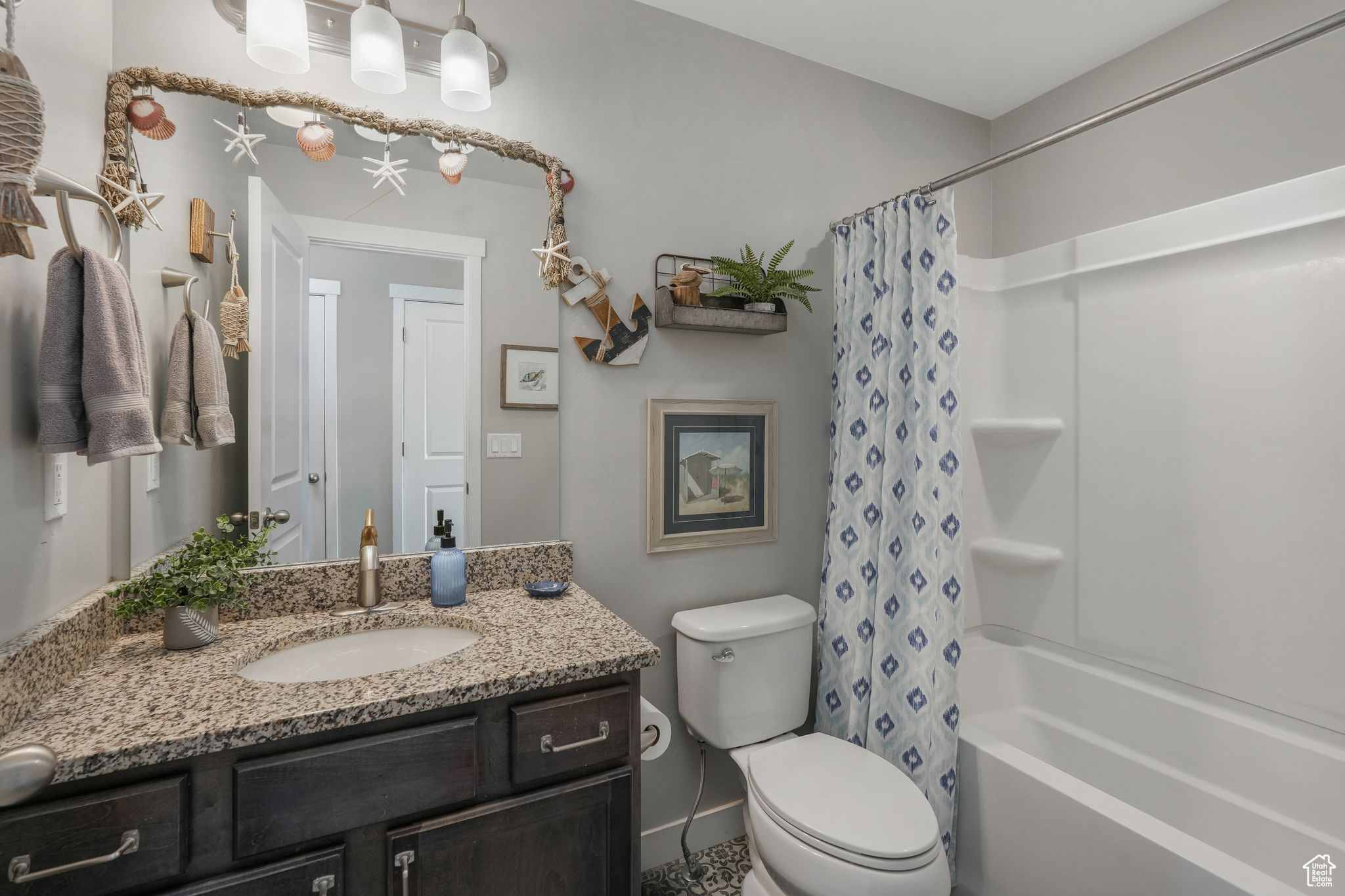 Full bathroom with toilet, vanity, and shower / tub combo with curtain