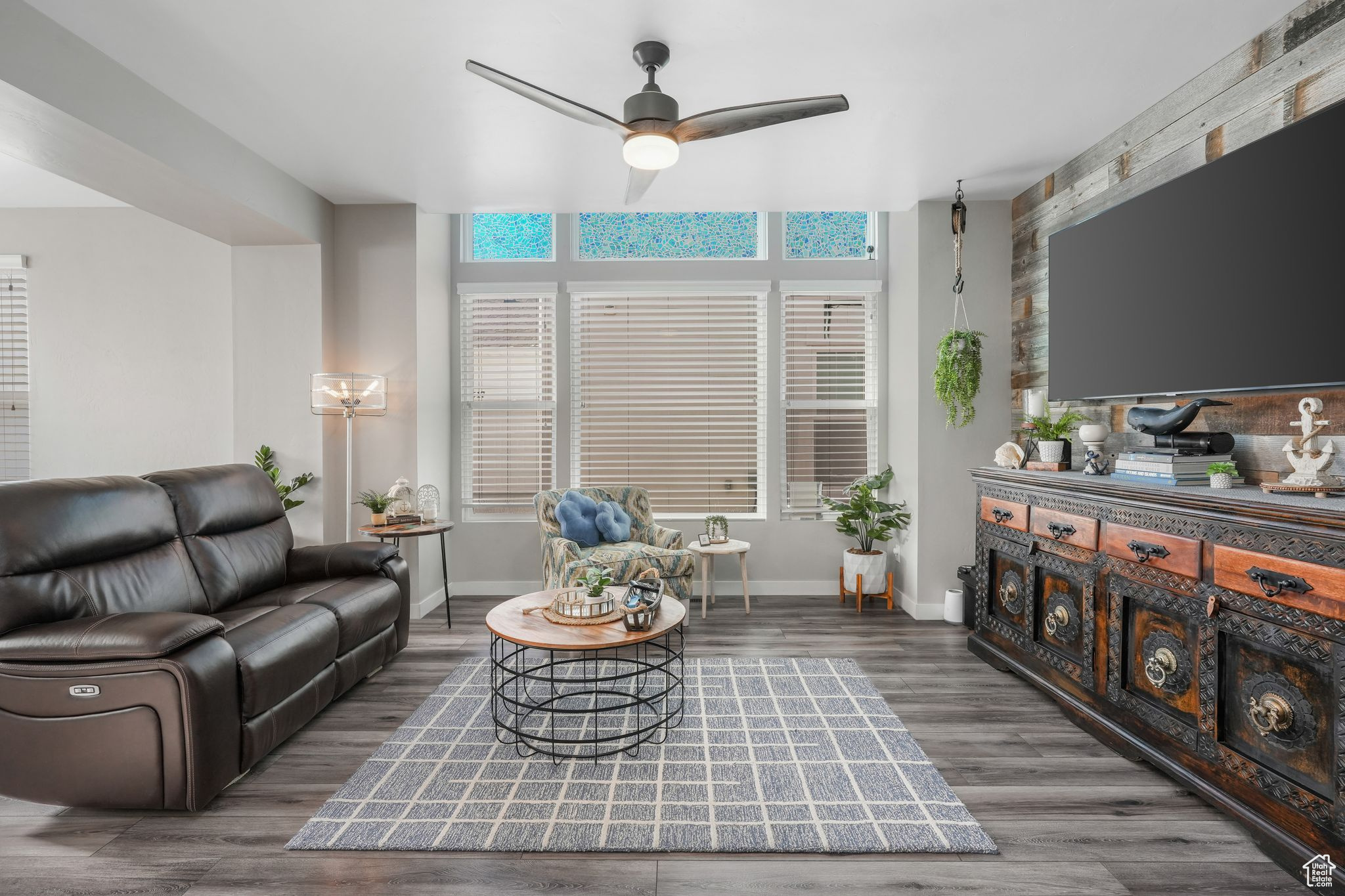 Living room featuring ceiling fan and dark wood-type flooring