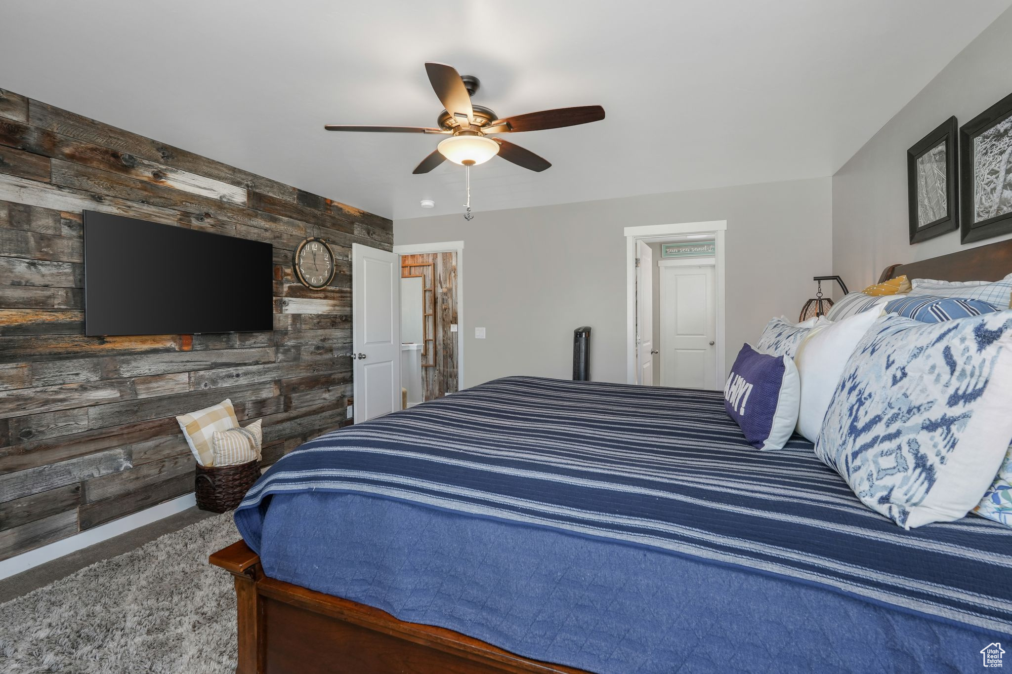 Carpeted bedroom with ceiling fan and wood walls