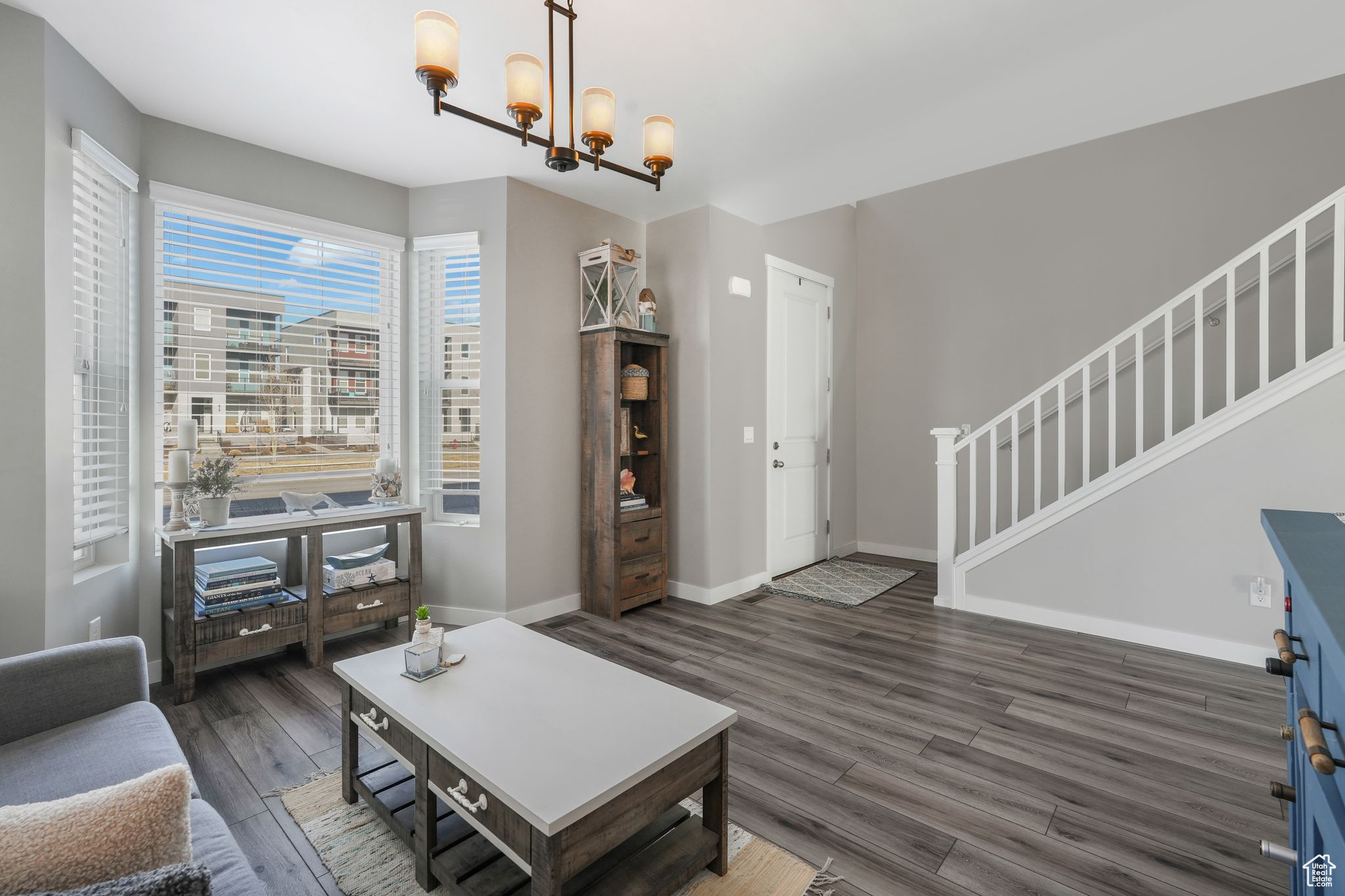 Living room featuring dark hardwood / wood-style flooring and a notable chandelier