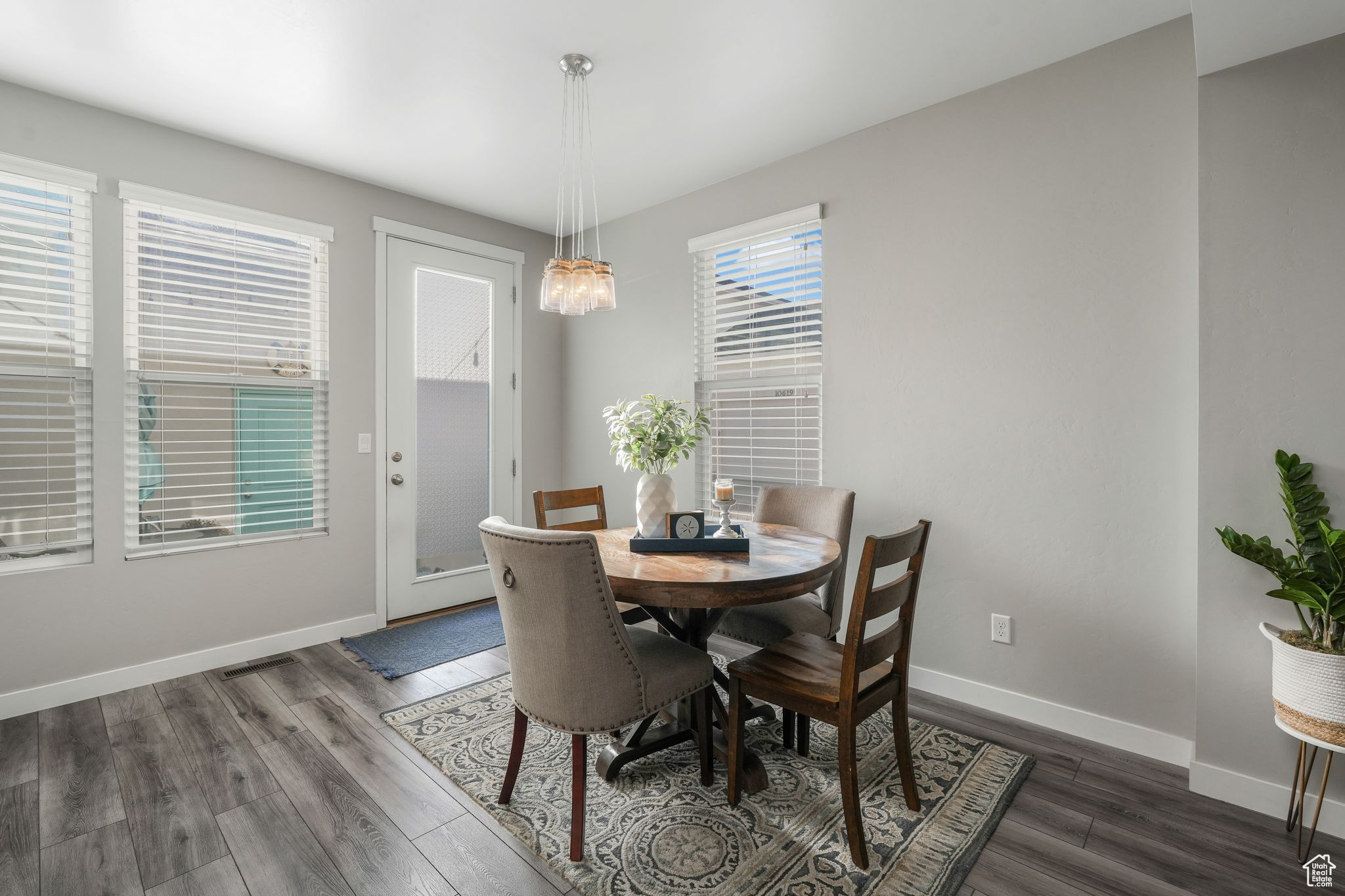 Dining room with dark hardwood / wood-style flooring and a notable chandelier