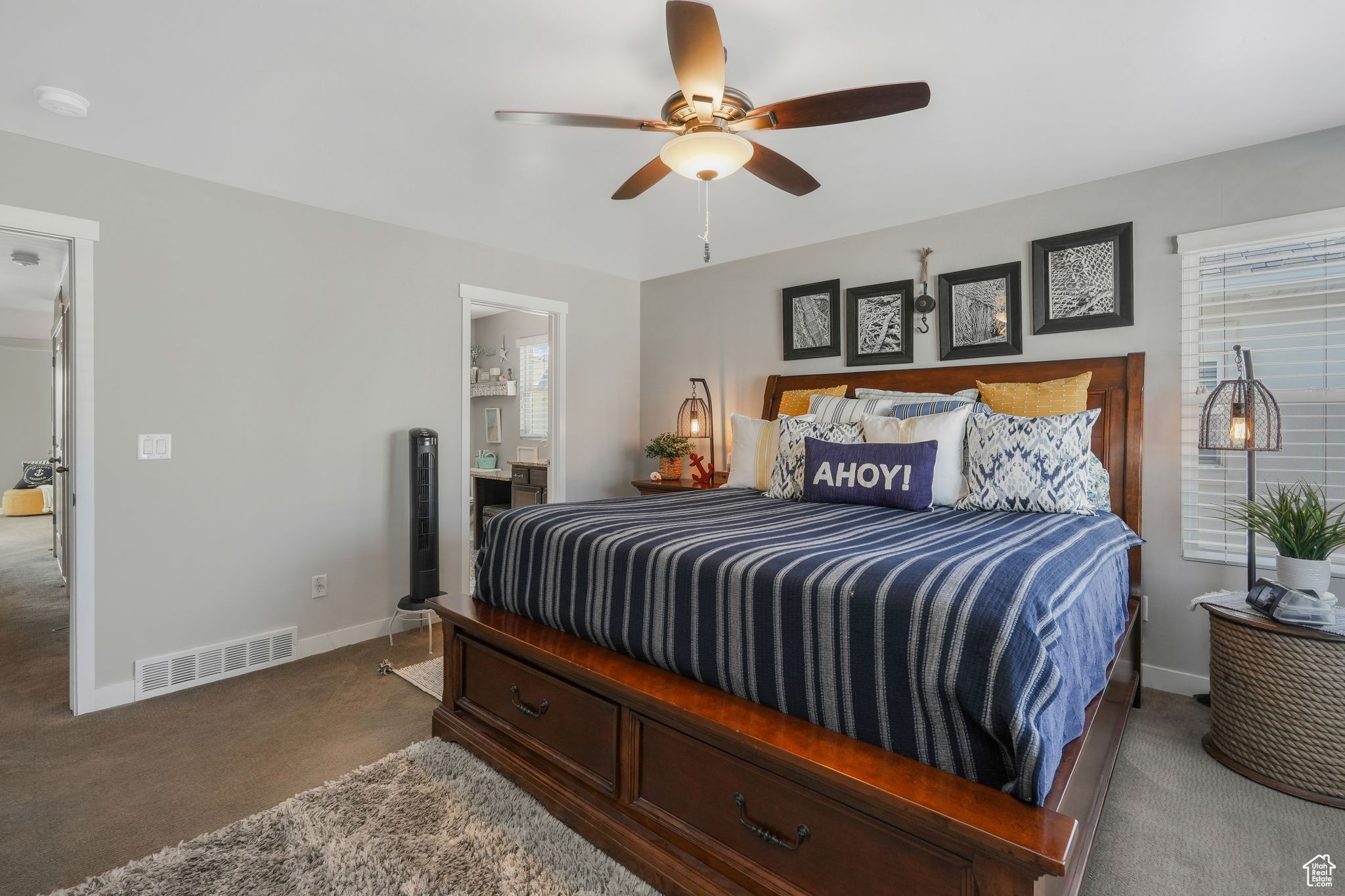 Carpeted bedroom featuring ceiling fan and ensuite bathroom