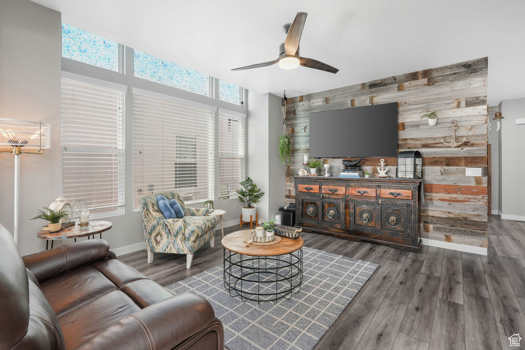 Living room with ceiling fan, dark hardwood / wood-style flooring, and wooden walls