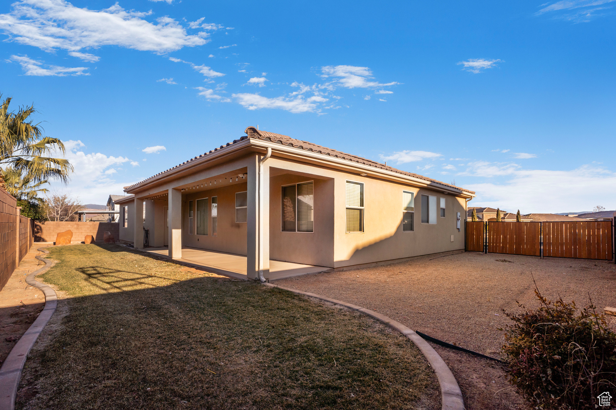 Back of house featuring a lawn and a patio