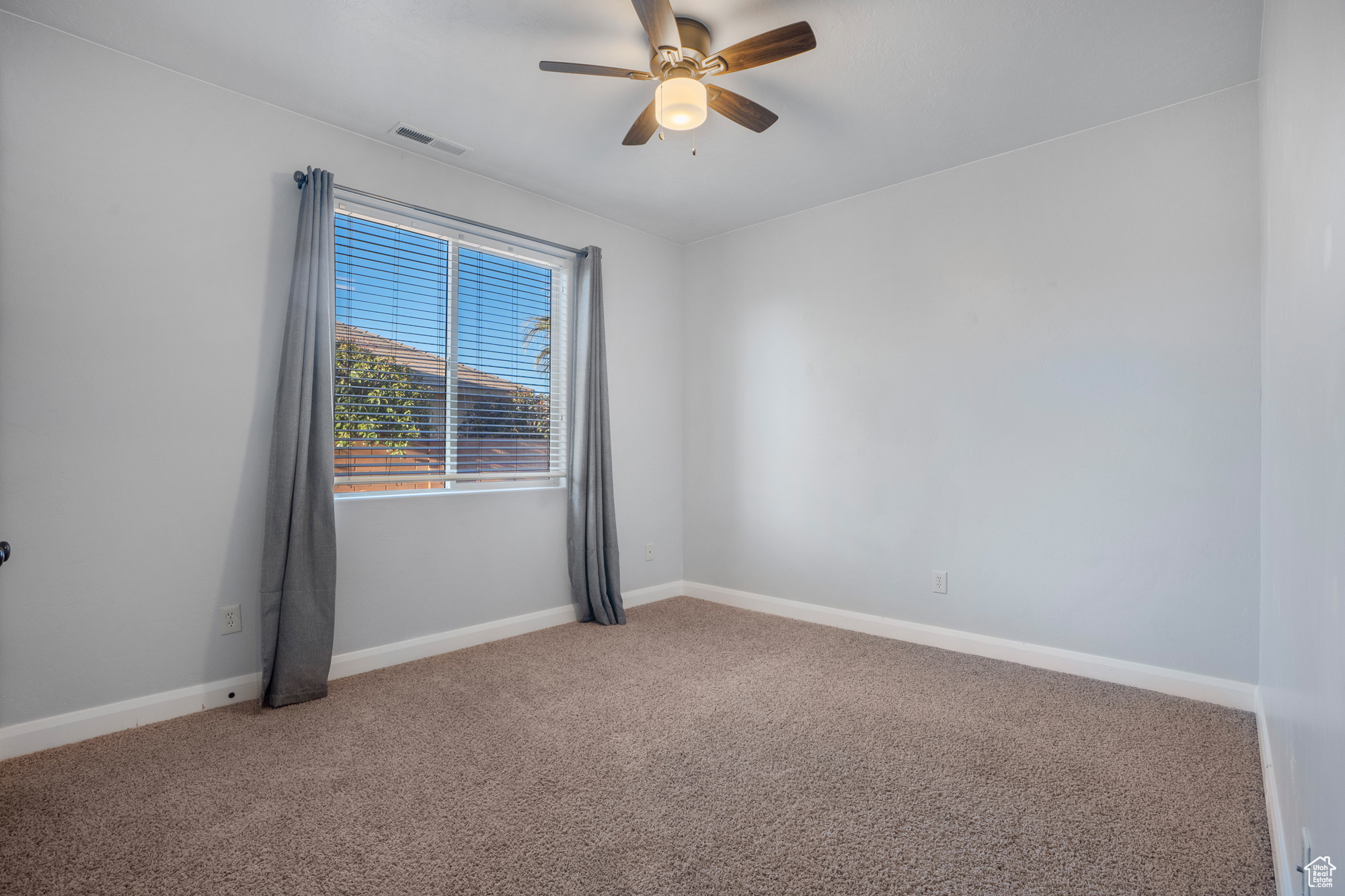 Unfurnished room with ceiling fan and carpet flooring