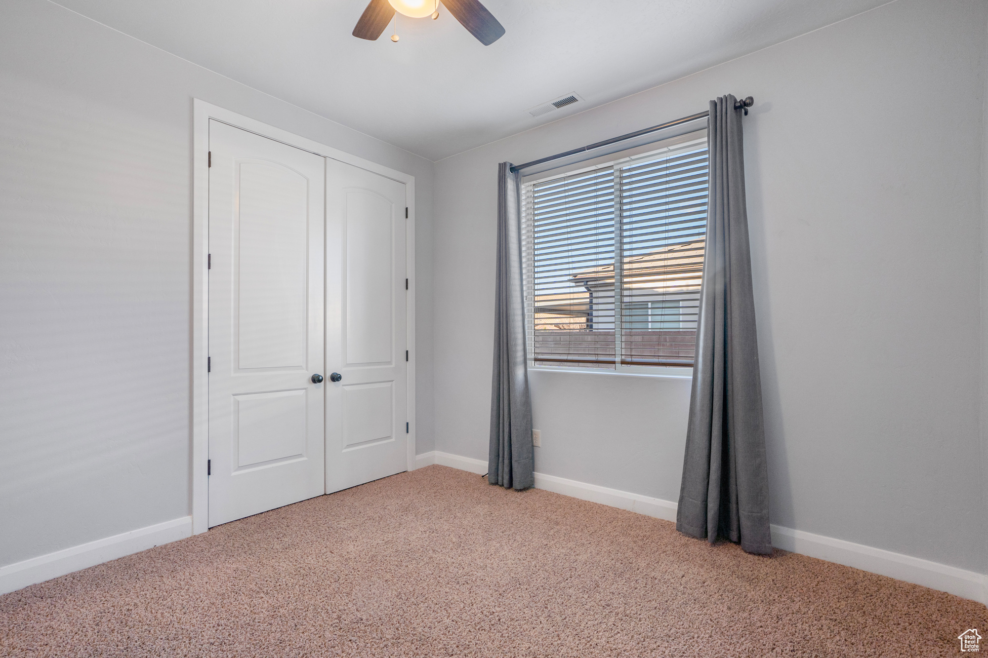 Unfurnished bedroom featuring ceiling fan, carpet flooring, and a closet