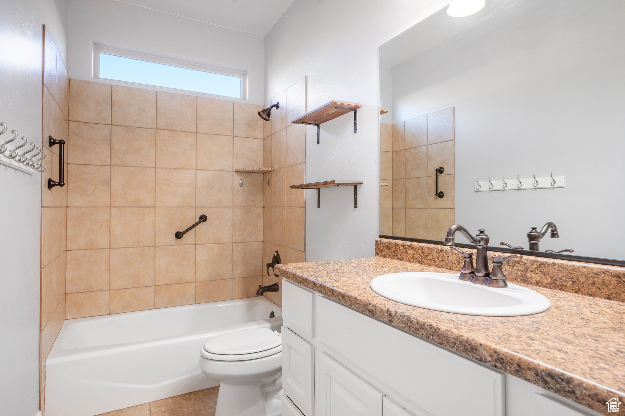 Full bathroom featuring tile patterned floors, toilet, vanity, and tiled shower / bath