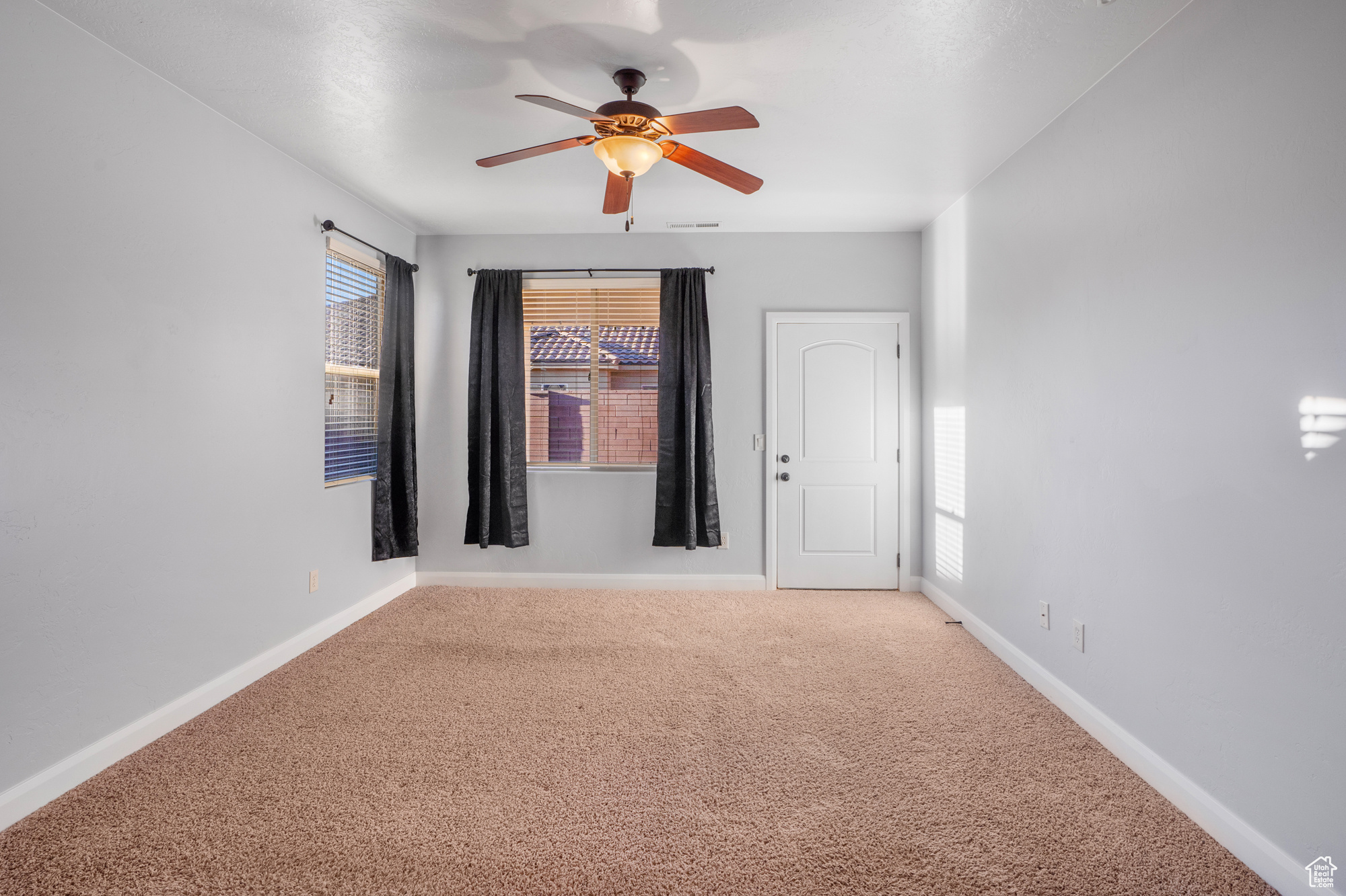 Spare room with ceiling fan and carpet