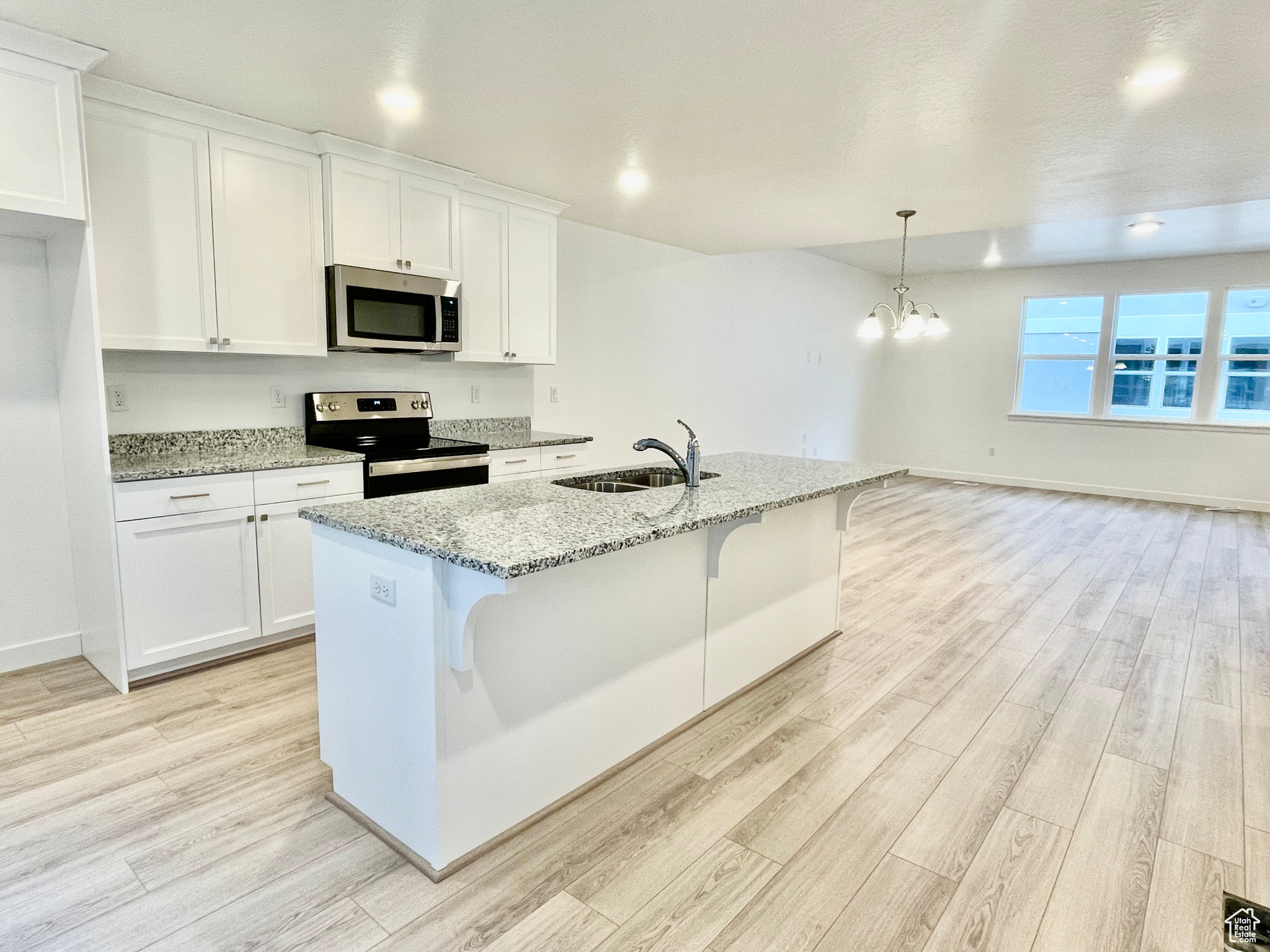 Kitchen with sink, stainless steel appliances, and white cabinetry