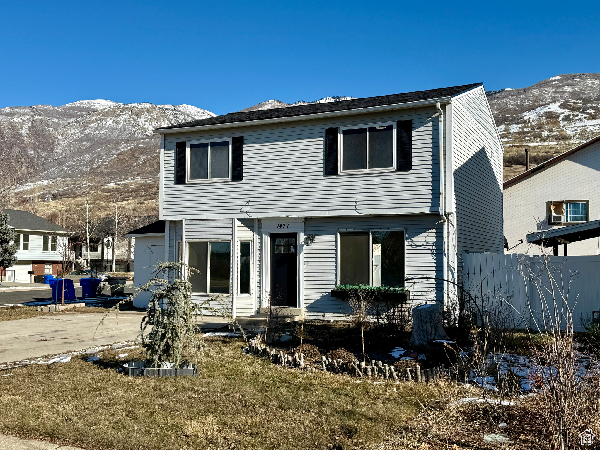 Rear view of property featuring a mountain view, a yard, and a patio