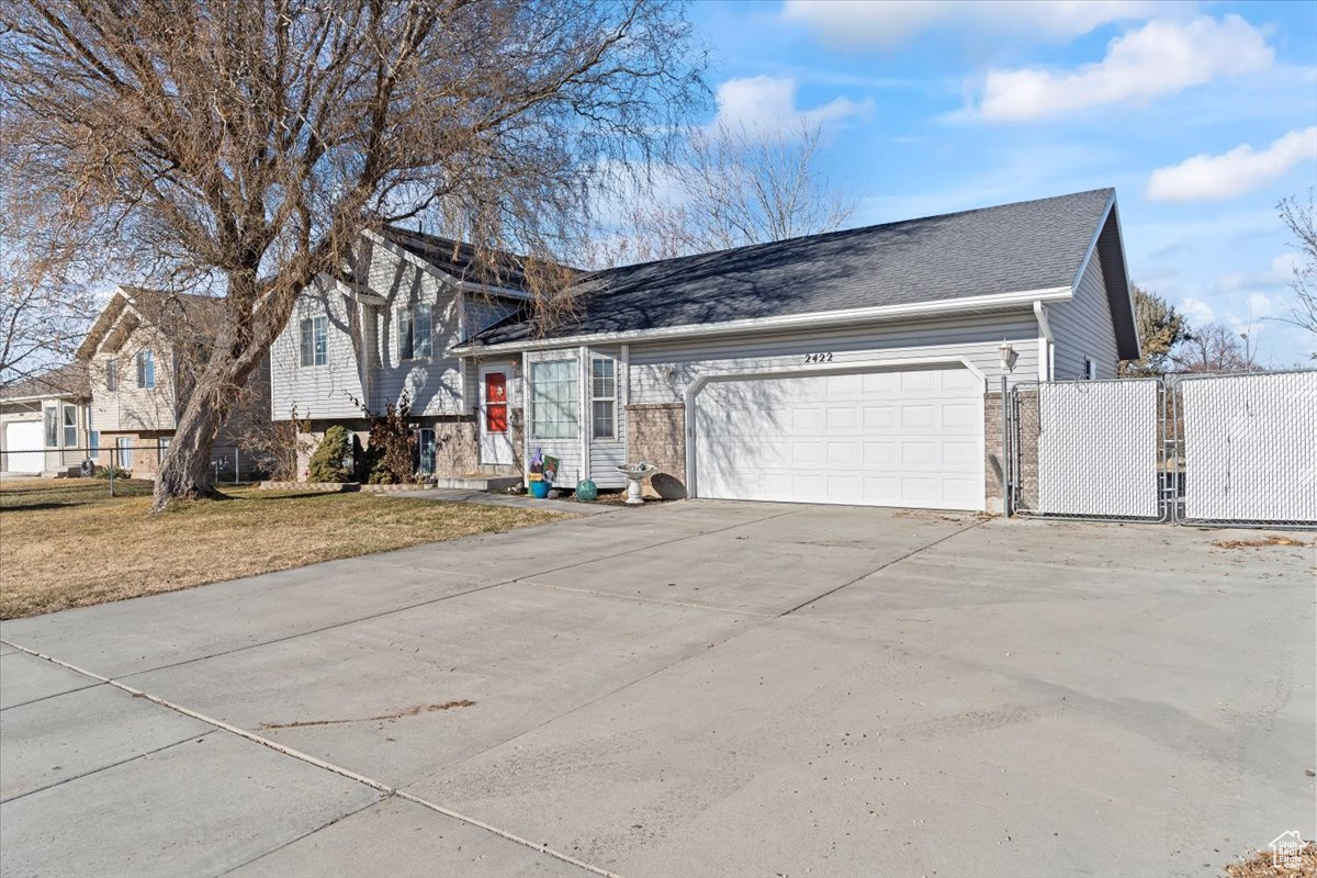 Tri-level home featuring a garage and a front yard