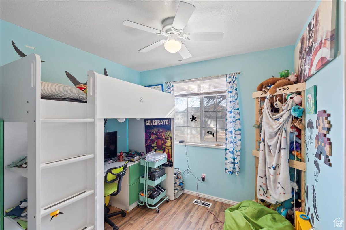 Bedroom featuring ceiling fan and hardwood / wood-style floors