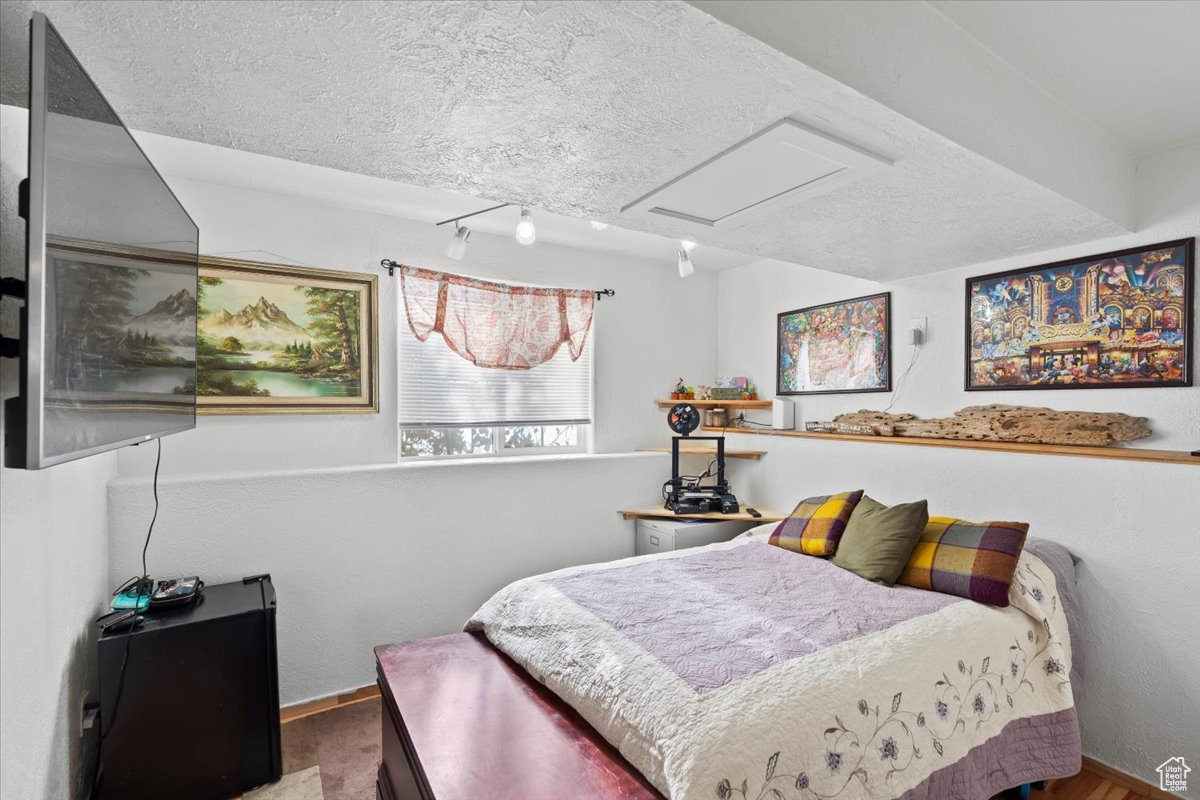 Bedroom featuring track lighting and a textured ceiling