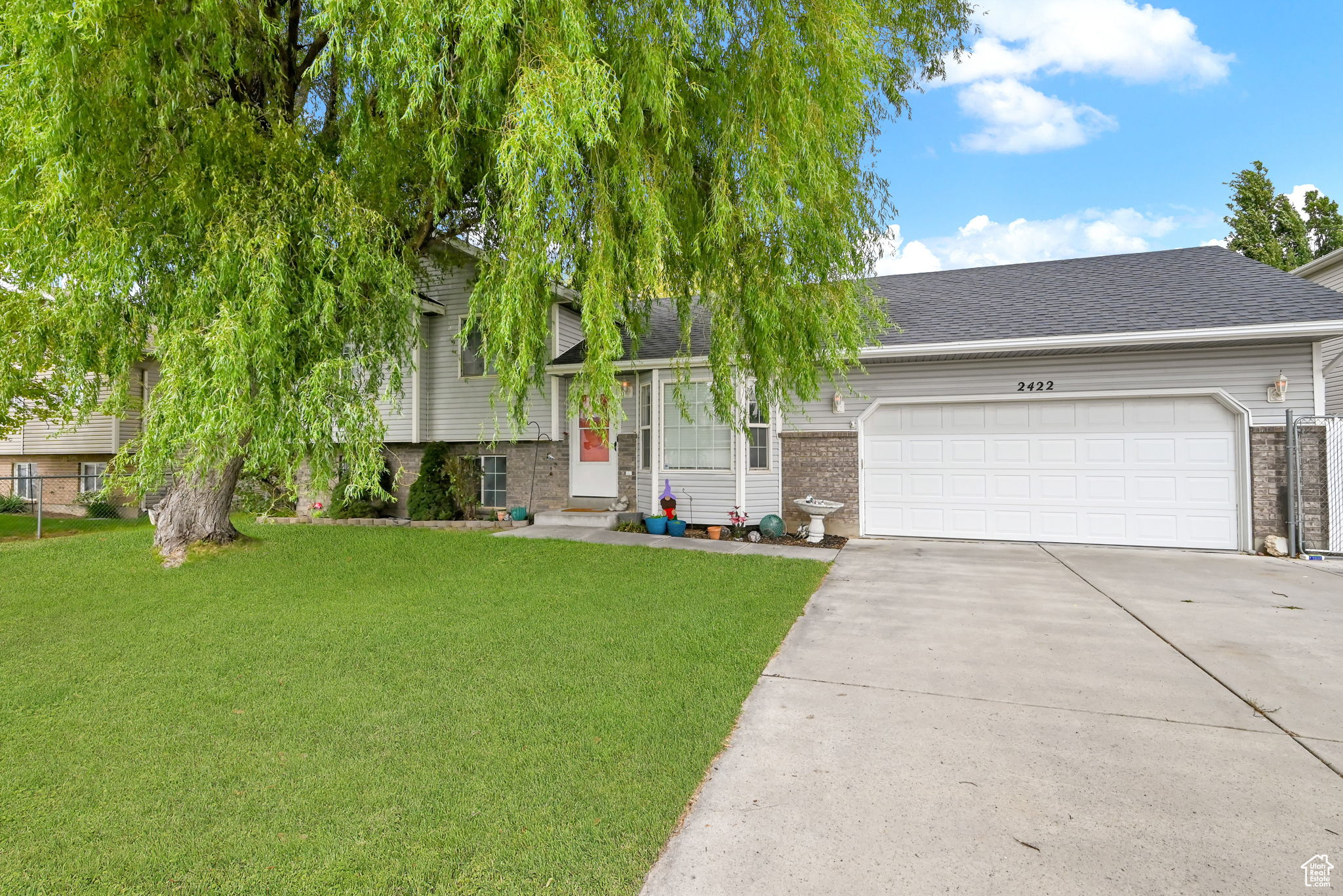 View of front of property with a front yard and a garage