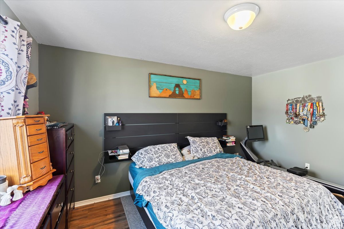 Bedroom with dark hardwood / wood-style floors