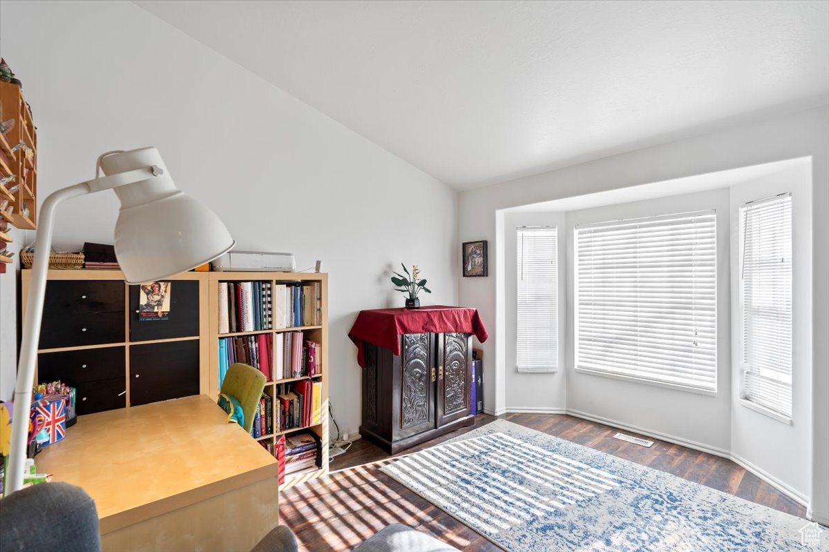 Bedroom with lofted ceiling and dark hardwood / wood-style flooring