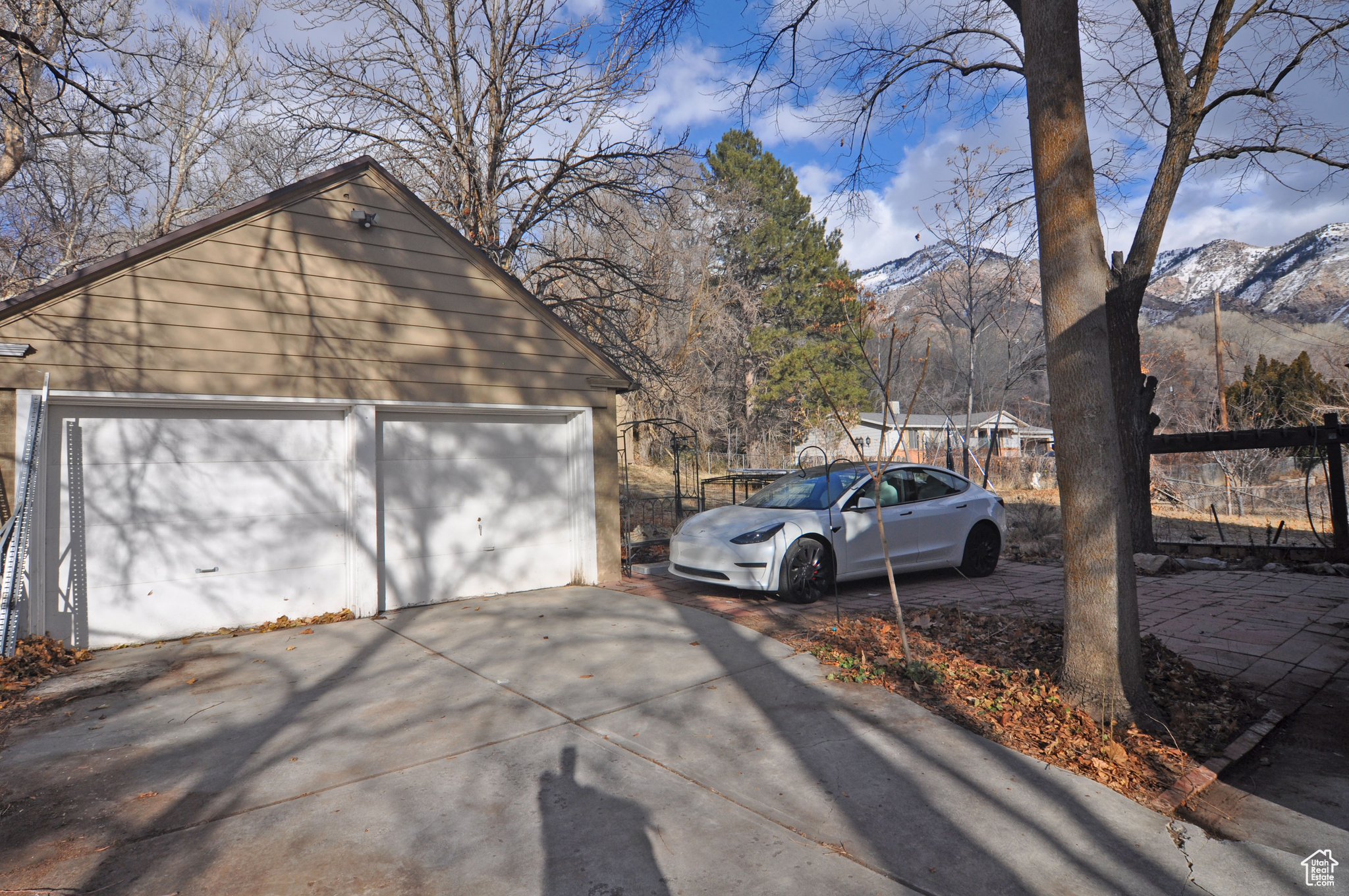 View of side of property featuring a garage, a mountain view, and an outbuilding