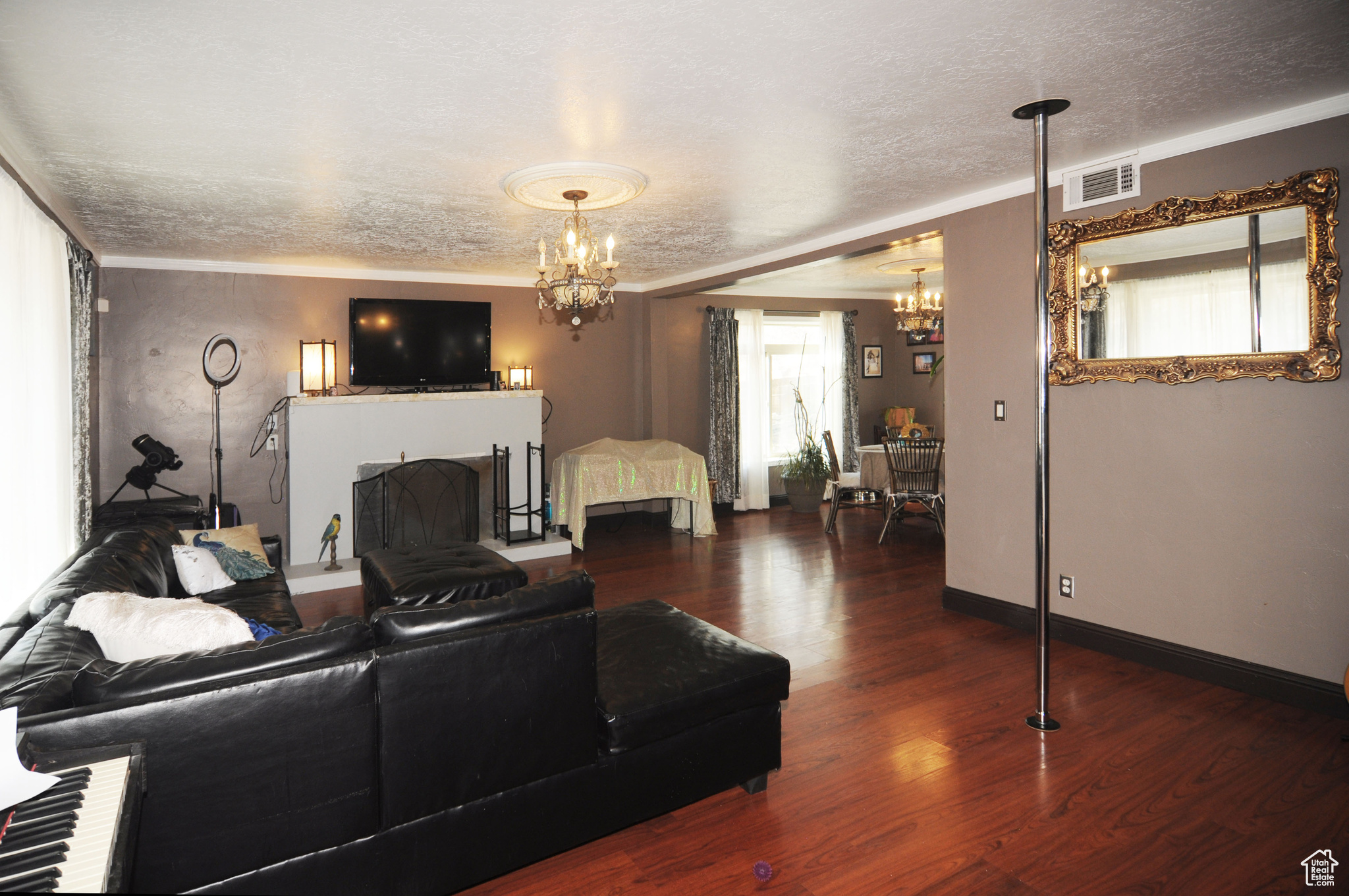 Living room featuring a chandelier, crown molding, and dark wood-type flooring