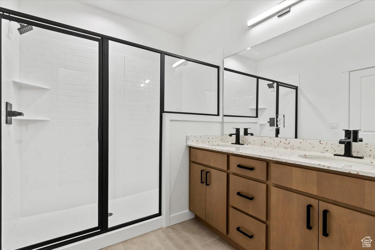 Bathroom featuring vanity and a shower with door