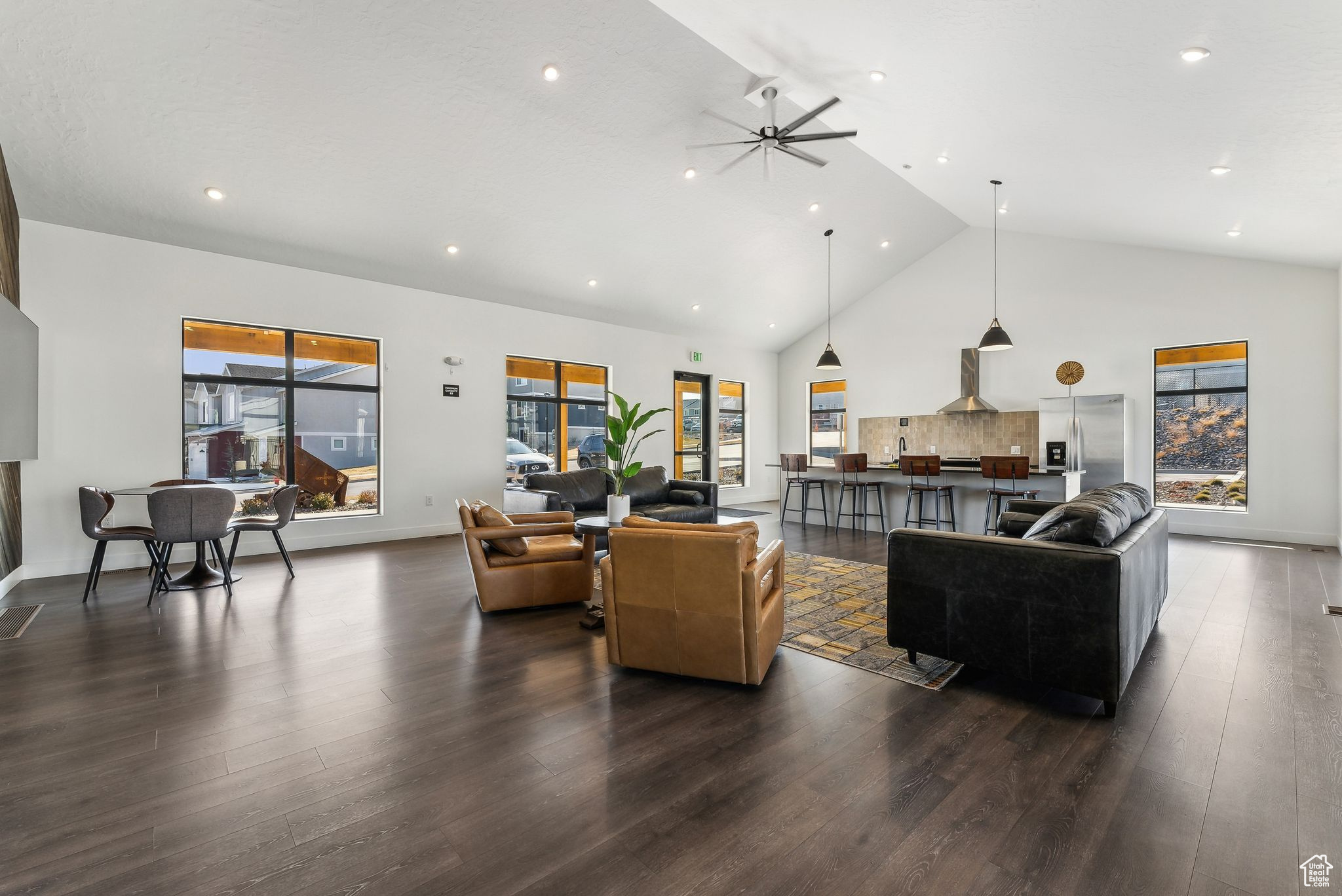 Living room featuring ceiling fan, dark hardwood / wood-style floors, high vaulted ceiling, and a wealth of natural light