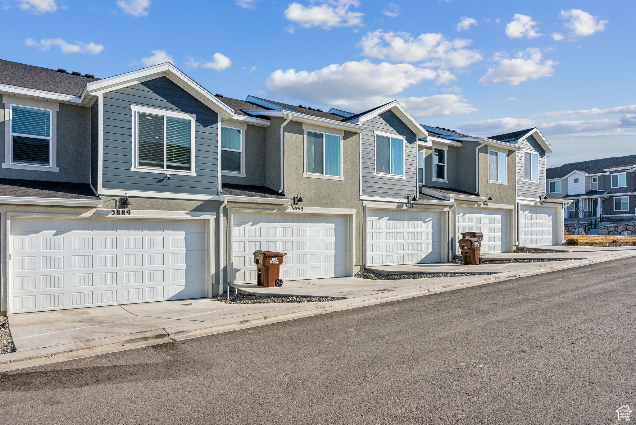 Townhome / multi-family property featuring a garage and solar panels