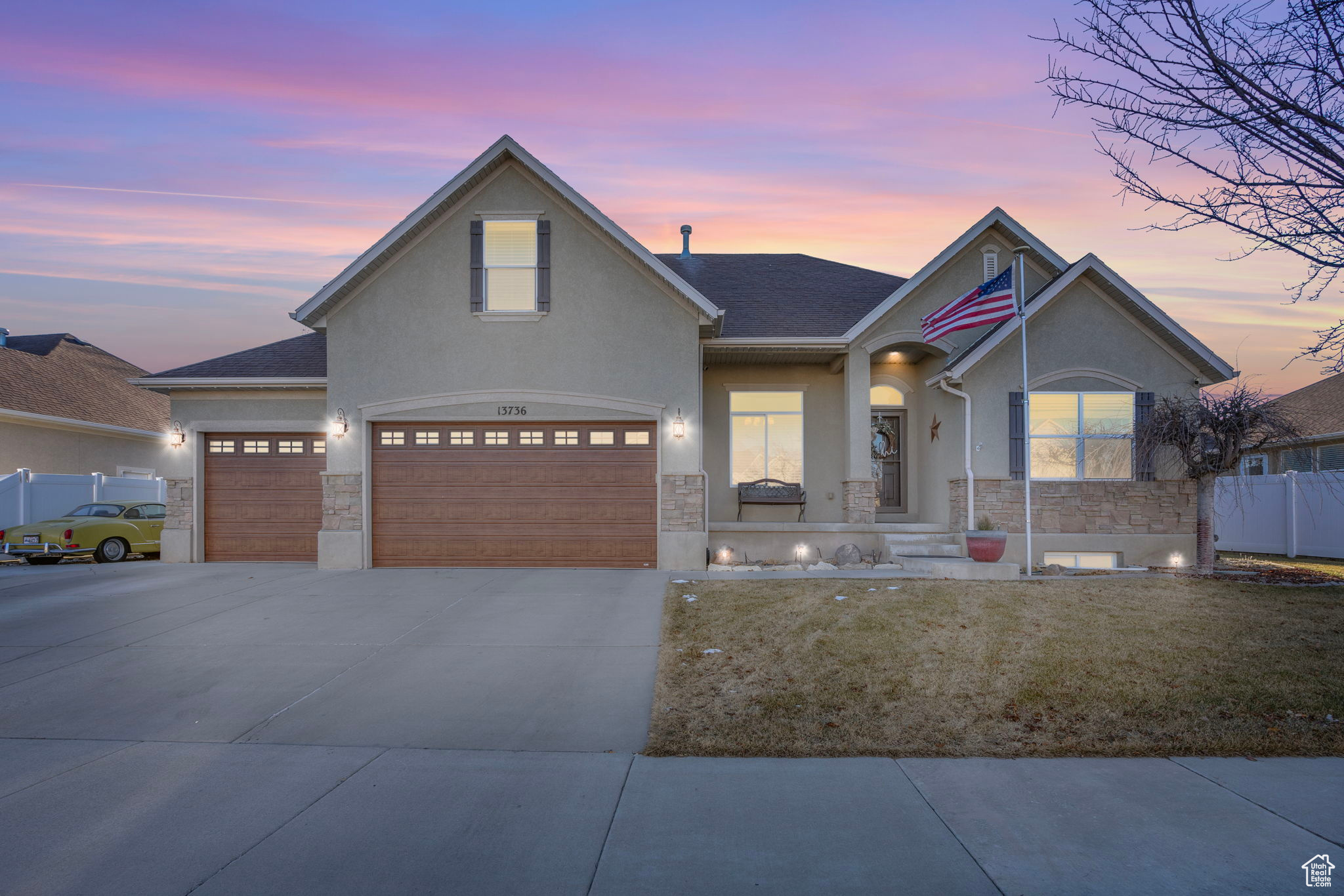 View of front facade featuring a garage and a yard