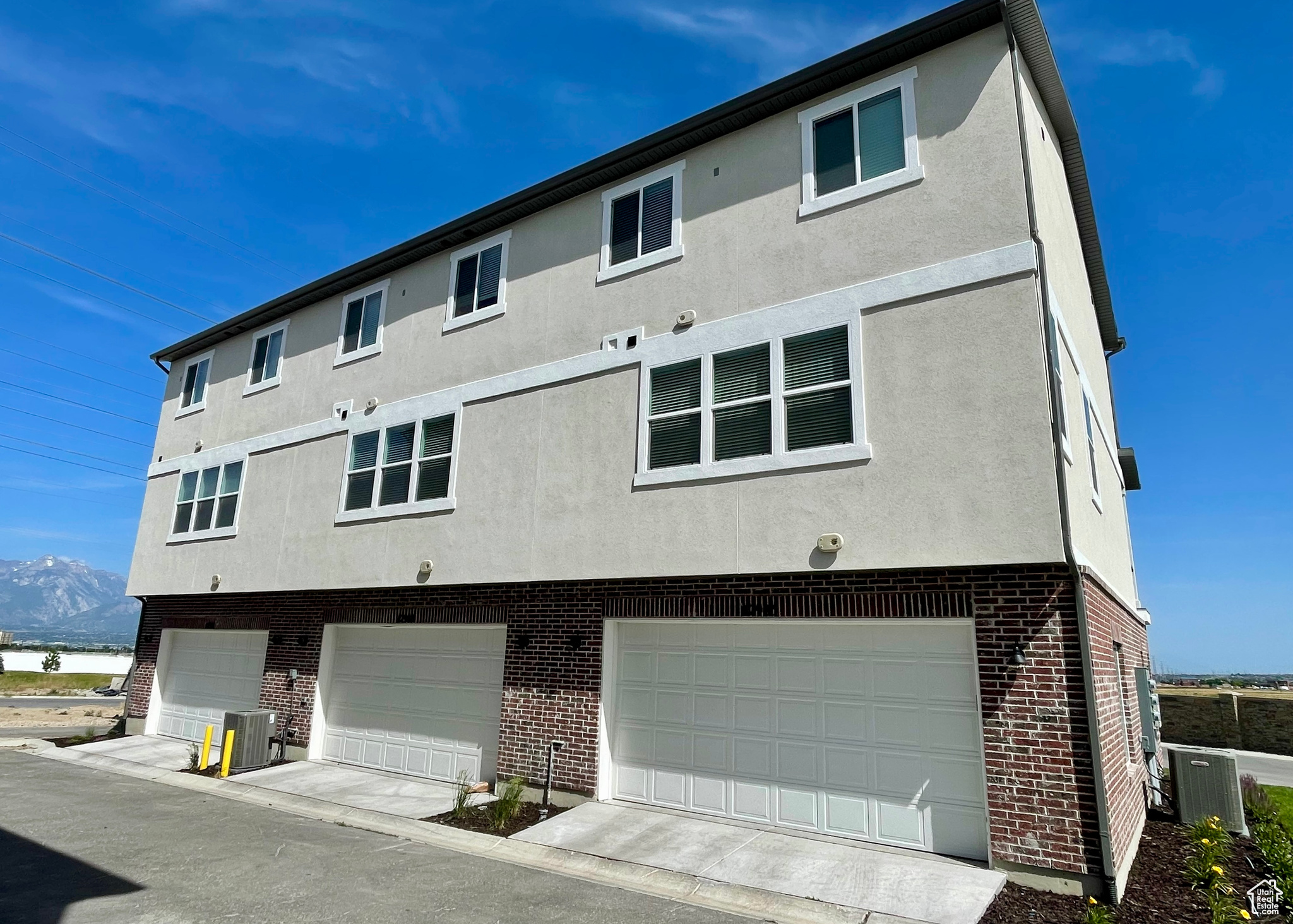 Exterior space featuring a garage, a mountain view, and cooling unit