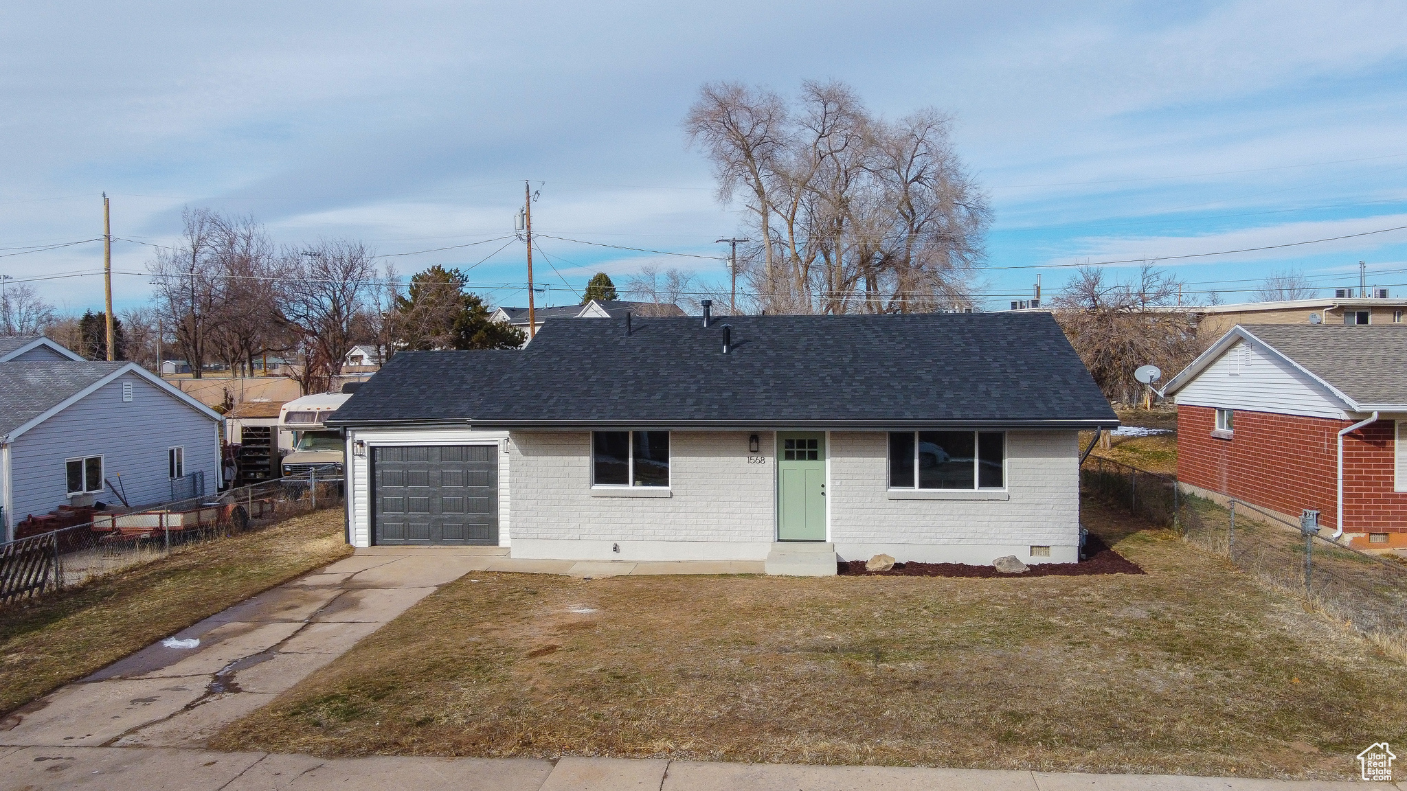 Single story home with a garage and a front lawn