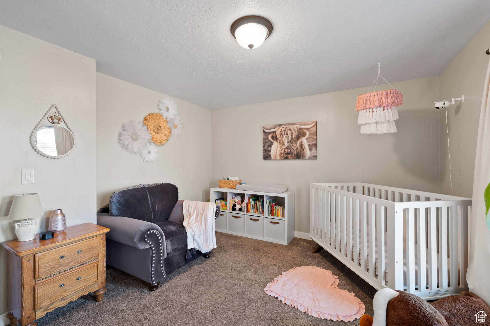 Bedroom featuring dark carpet and a crib