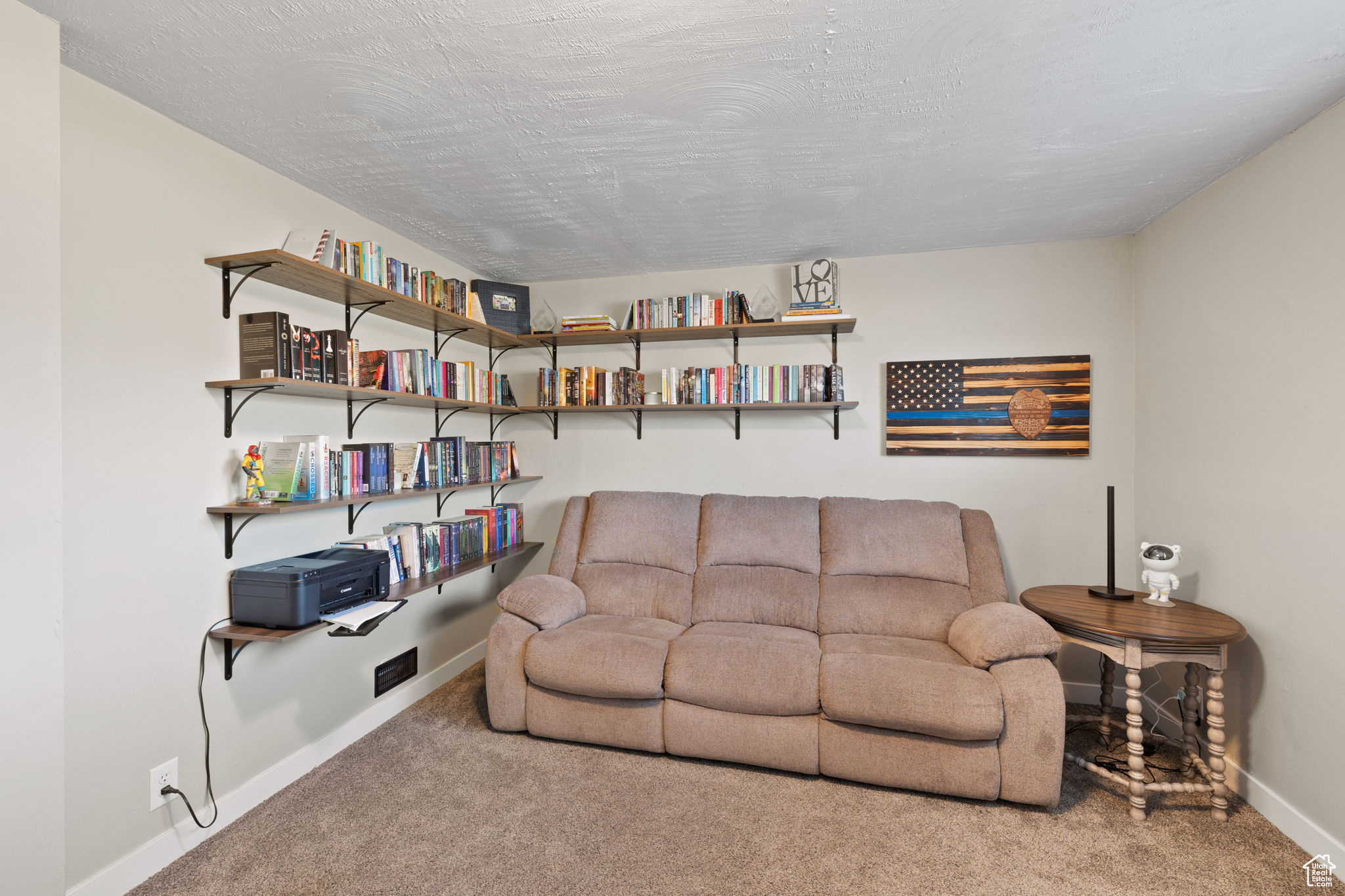 Carpeted living room with a textured ceiling