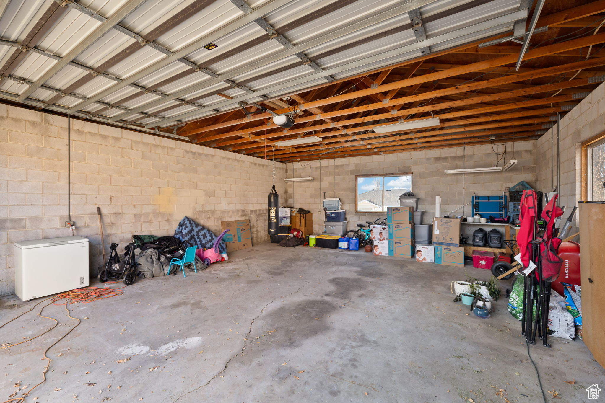 Garage featuring refrigerator and a garage door opener