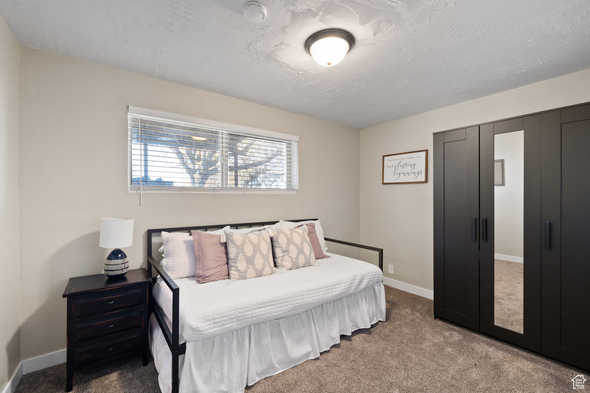 Carpeted bedroom with a textured ceiling