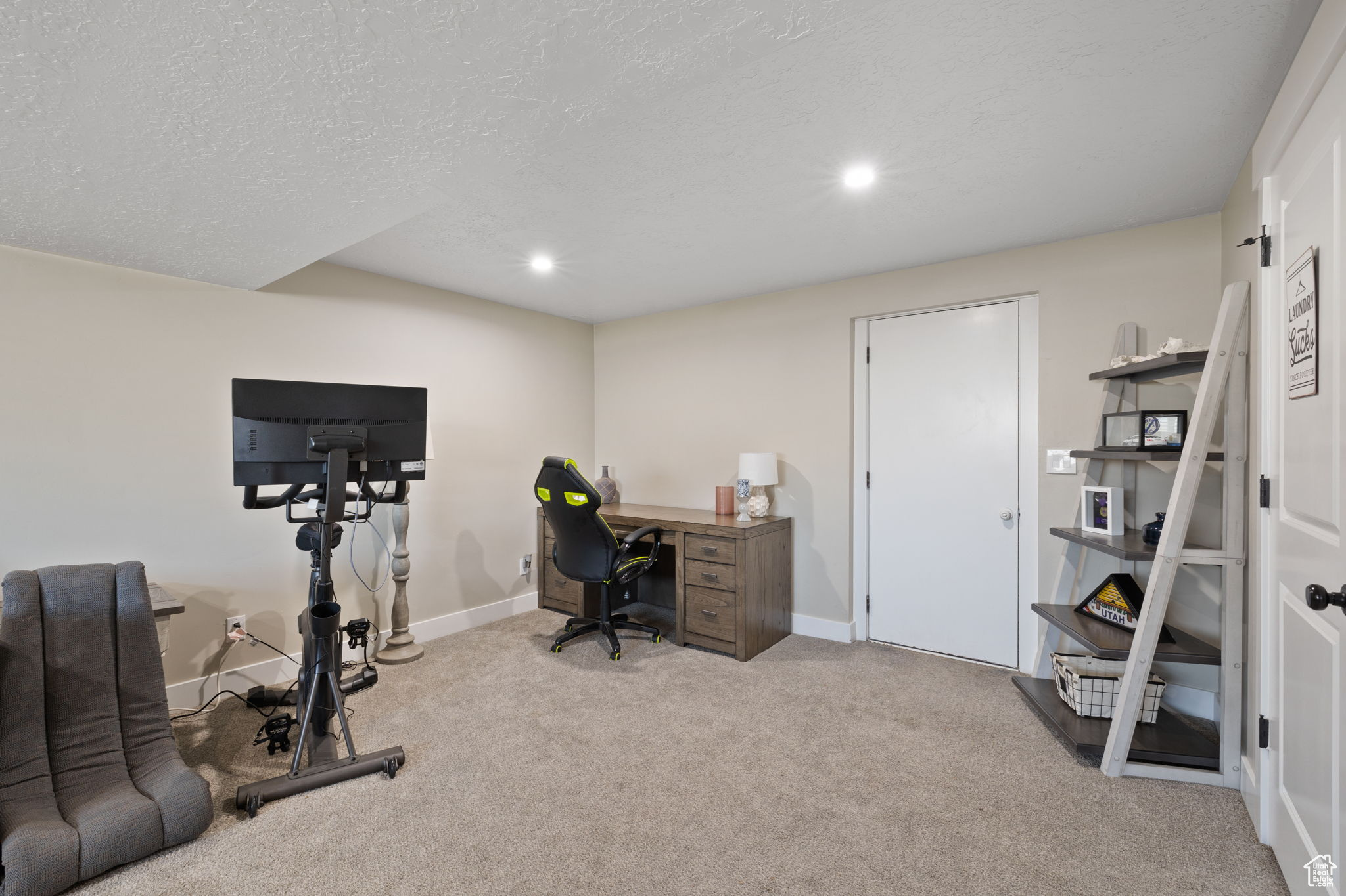 Carpeted office featuring a textured ceiling