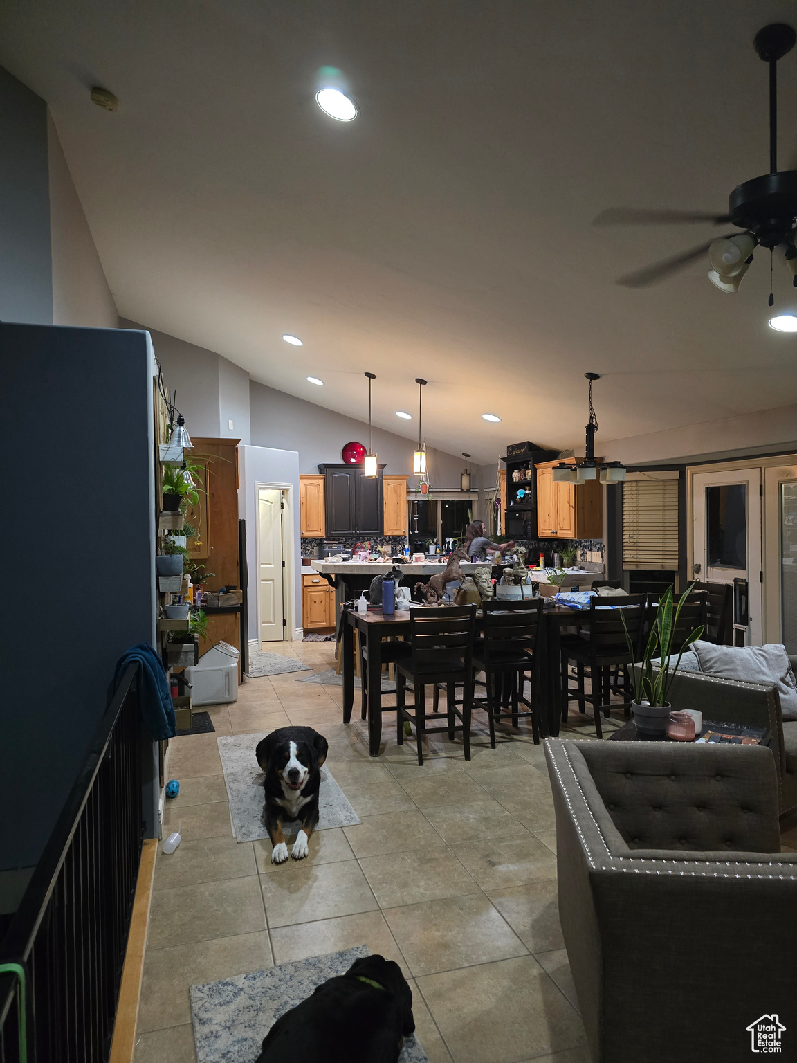 Tiled dining space with vaulted ceiling and ceiling fan