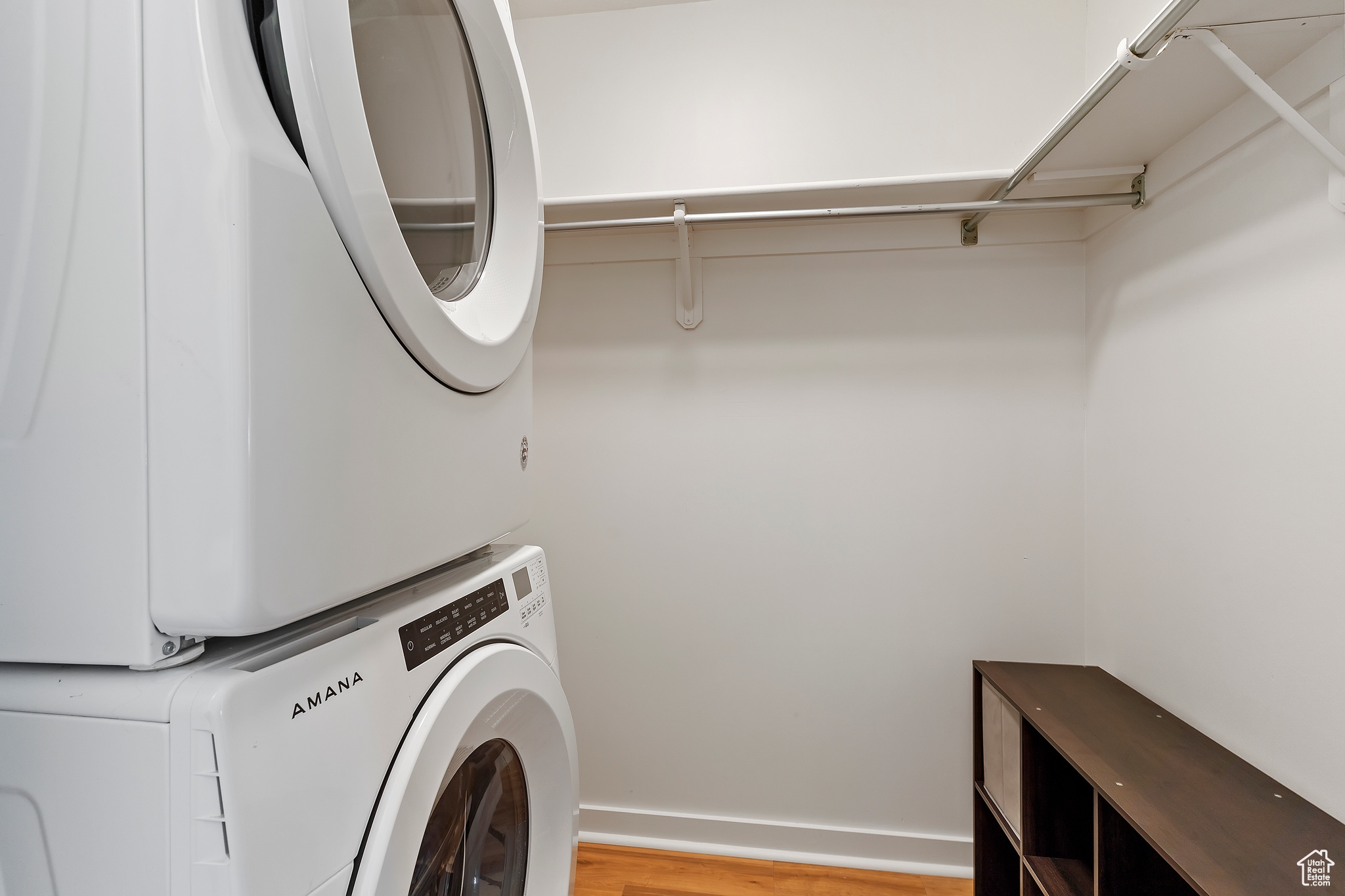 Washroom featuring stacked washer and dryer and light hardwood / wood-style flooring