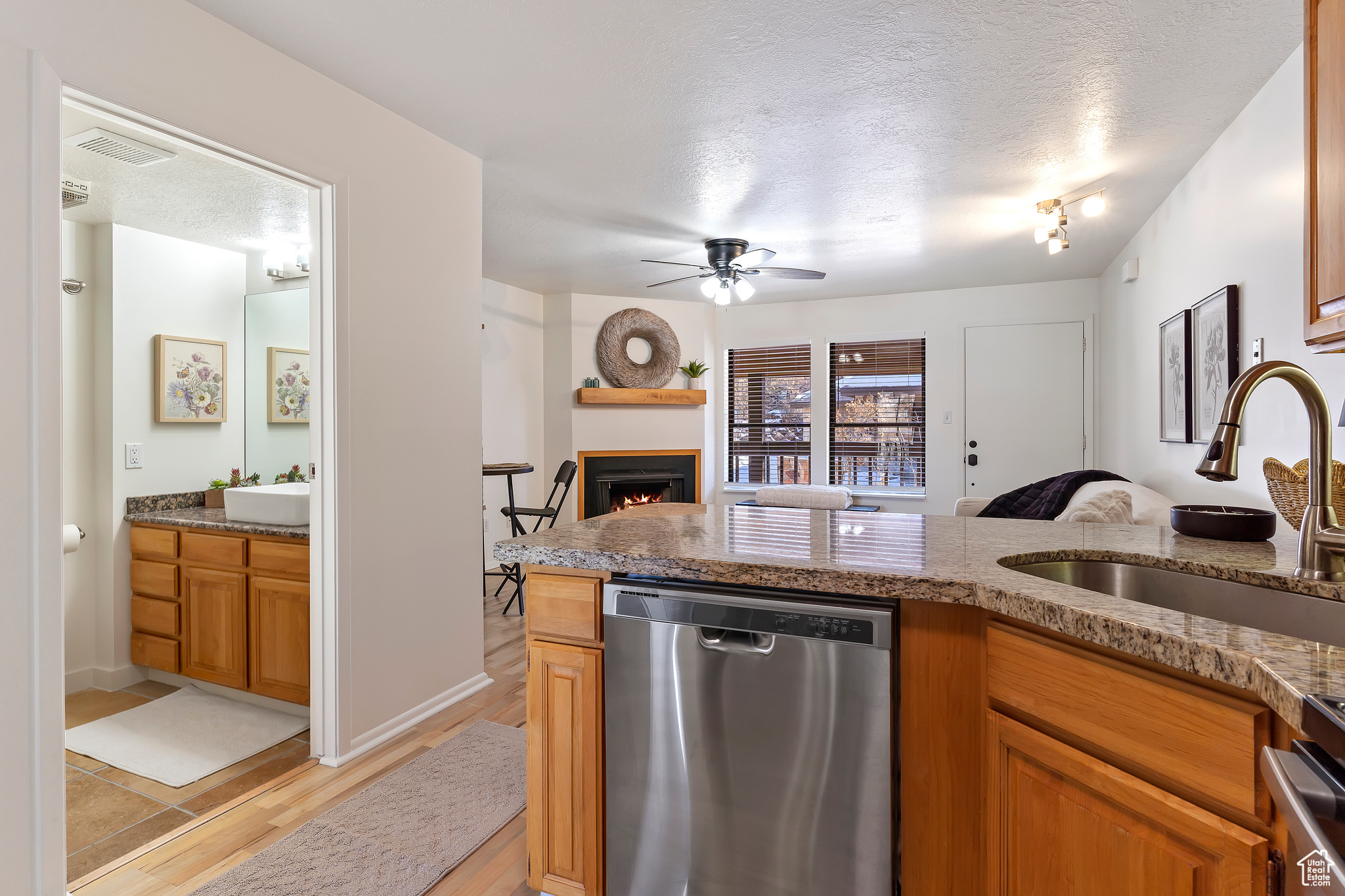 Kitchen featuring sink, a textured ceiling, light hardwood / wood-style floors, and dishwasher